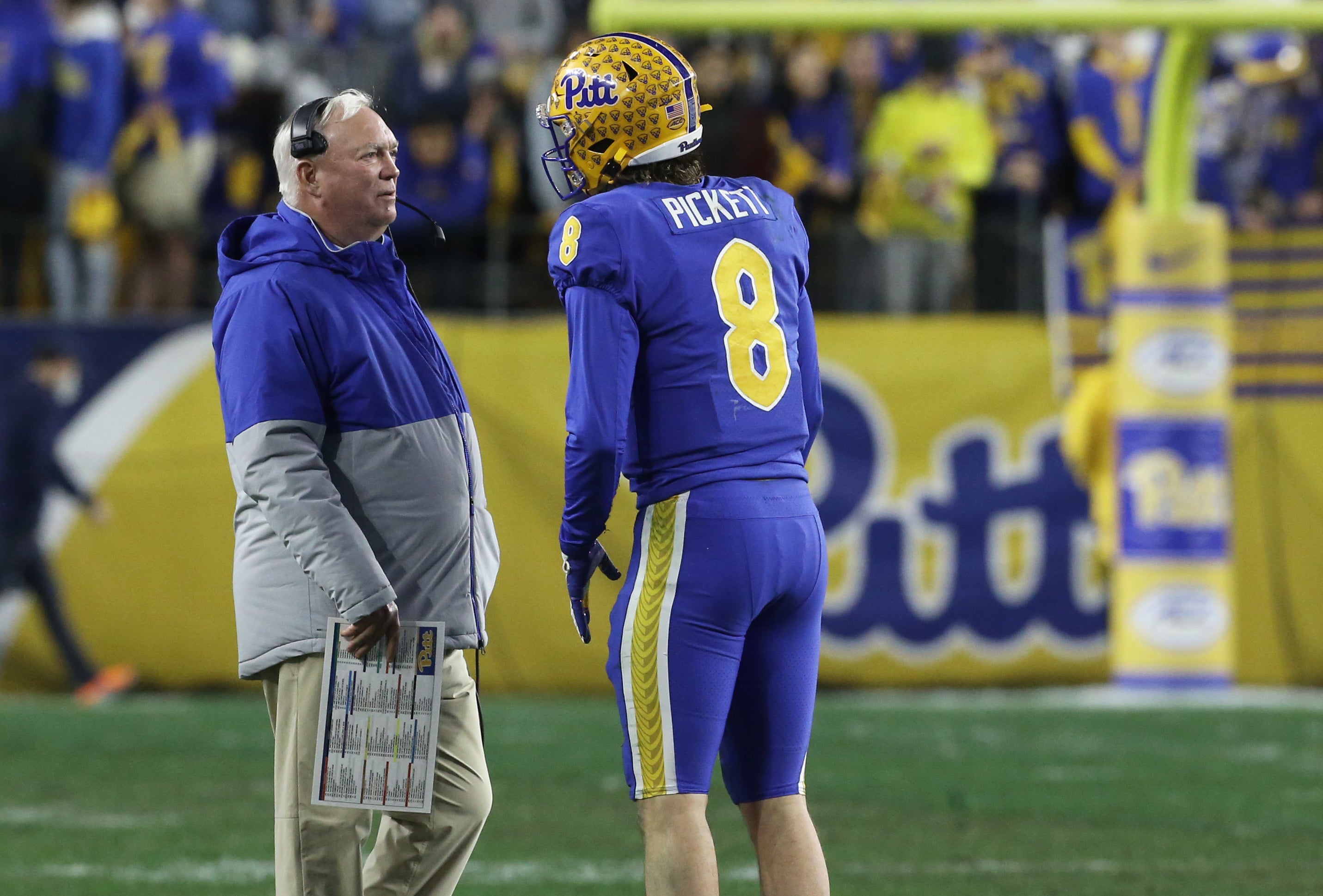 Nov 20, 2021; Pittsburgh, Pennsylvania, USA; Pittsburgh Panthers offensive coordinator Mark Whipple (left) talks with quarterback Kenny Pickett (8) on the sidelines against the Virginia Cavaliers during the fourth quarter at Heinz Field. Mandatory Credit: Charles LeClaire-USA TODAY Sports  