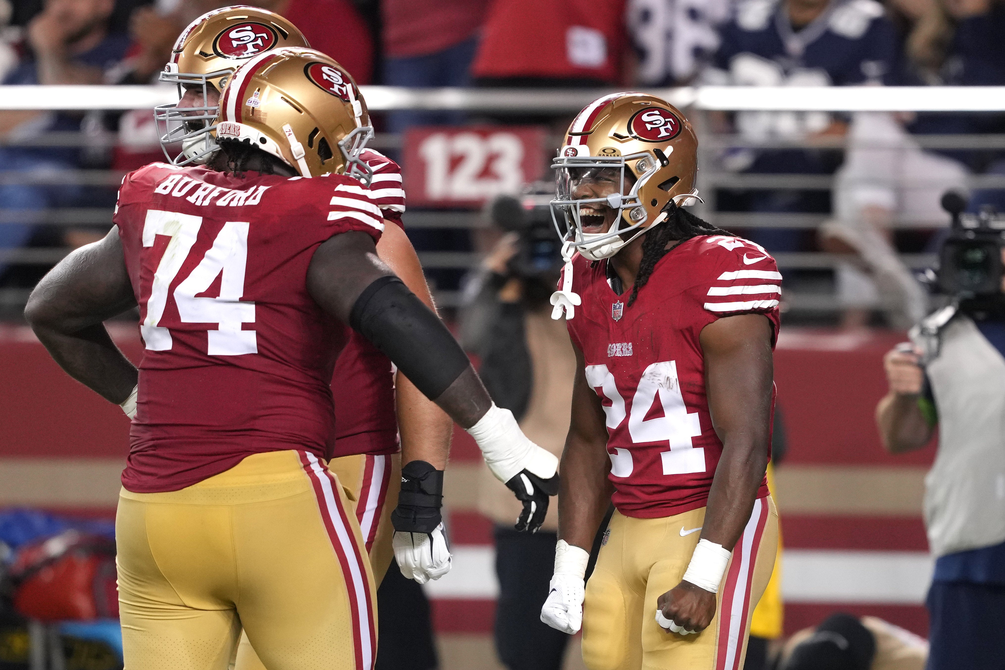 Oct 8, 2023; Santa Clara, California, USA; San Francisco 49ers running back Jordan Mason (24) celebrates with offensive tackle Spencer Burford (74) after scoring a touchdown against the Dallas Cowboys during the fourth quarter at Levi's Stadium. Mandatory Credit: