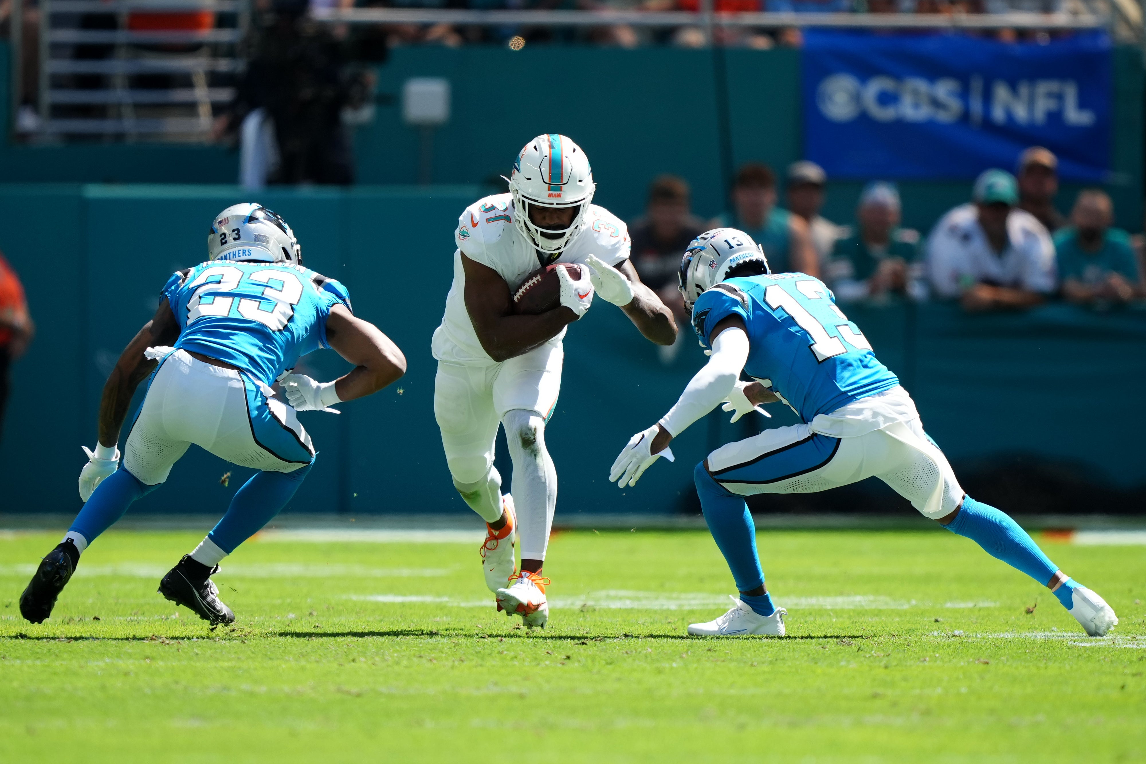 Oct 15, 2023; Miami Gardens, Florida, USA; Miami Dolphins running back Raheem Mostert (31) runs the ball against Carolina Panthers cornerback CJ Henderson (23) and cornerback Troy Hill (13) during the first half at Hard Rock Stadium. Mandatory Credit: Jasen Vinlove-USA TODAY Sports