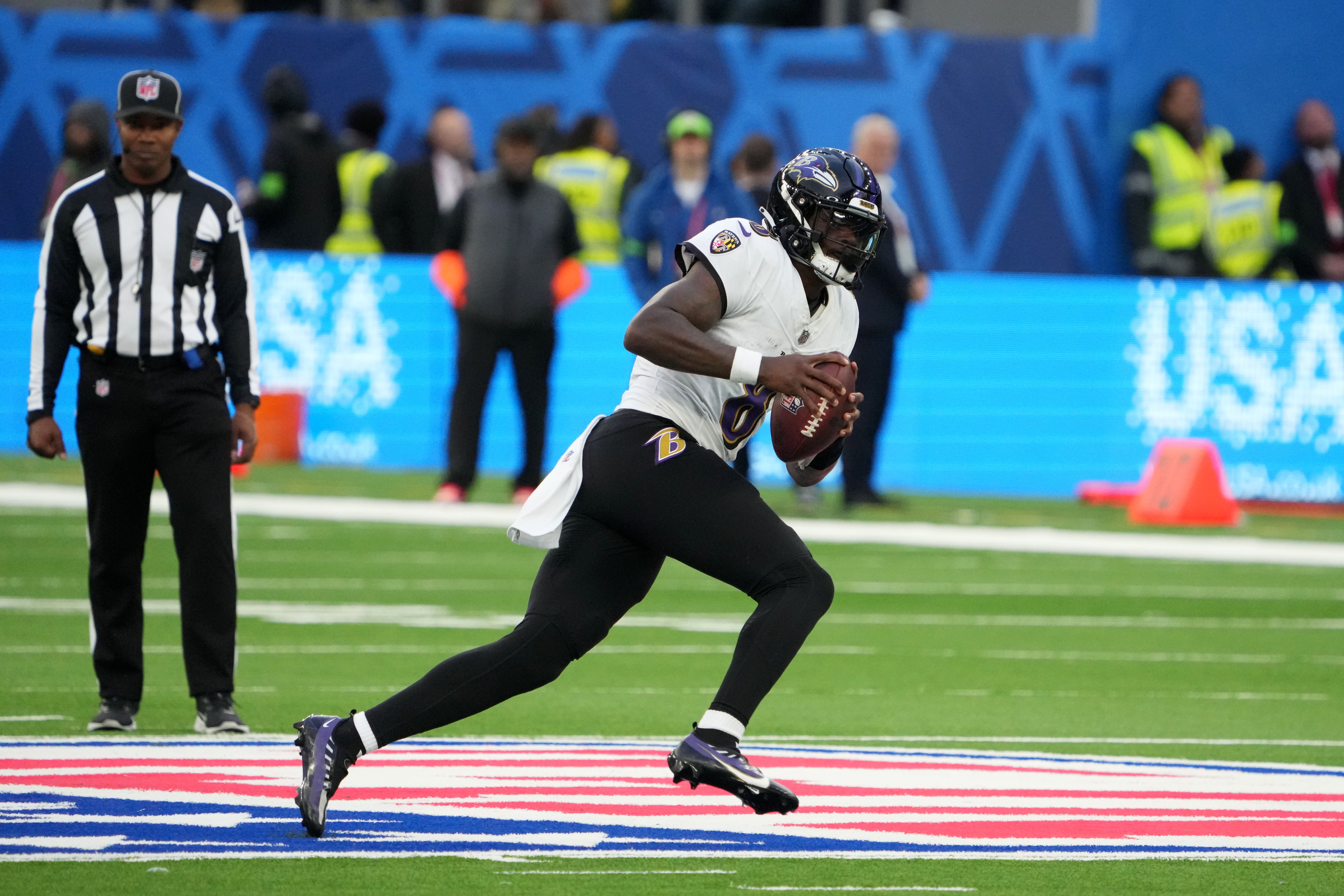 Baltimore Ravens quarterback Lamar Jackson (8) carries the ball against the Tennessee Titans in the second half during an NFL International Series game at Tottenham Hotspur Stadium.