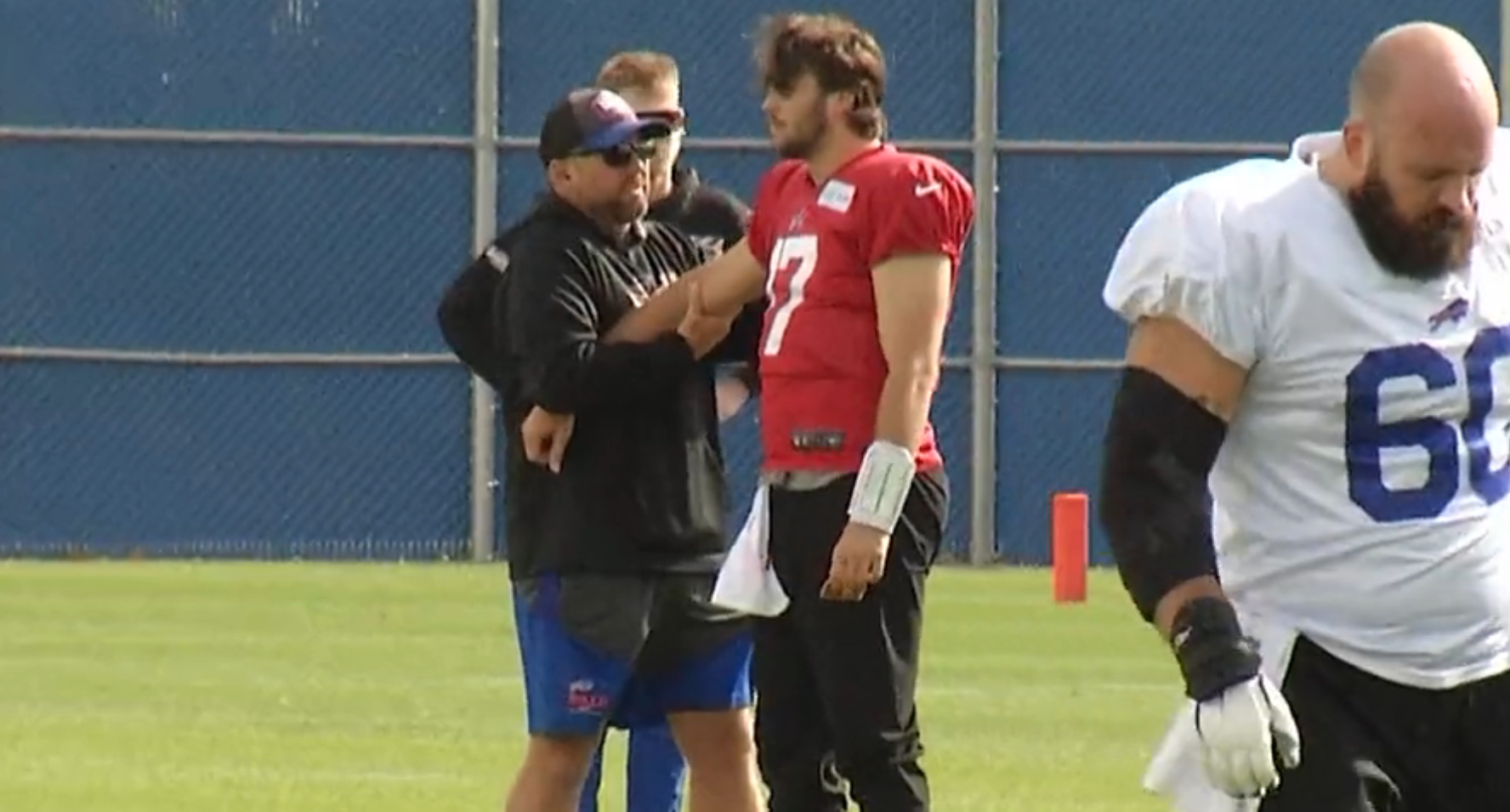 Buffalo Bills QB stretching with athletic trainers during practice