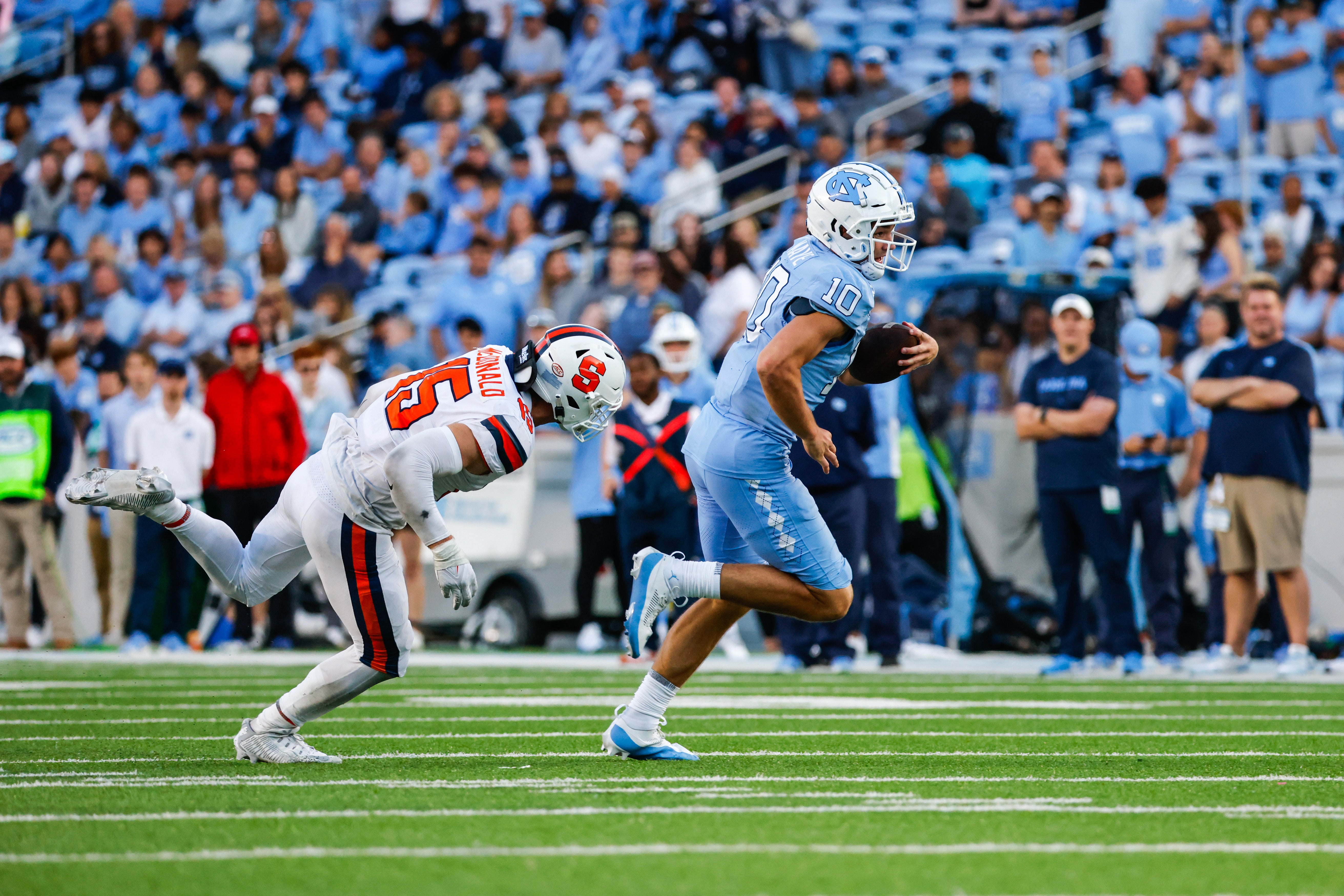 Oct 7, 2023; Chapel Hill, North Carolina, USA; North Carolina Tar Heels quarterback Drake Maye (10) evades Syracuse Orange linebacker Derek McDonald (15) during the second half of the game against the Syracuse Orange at Kenan Memorial Stadium.