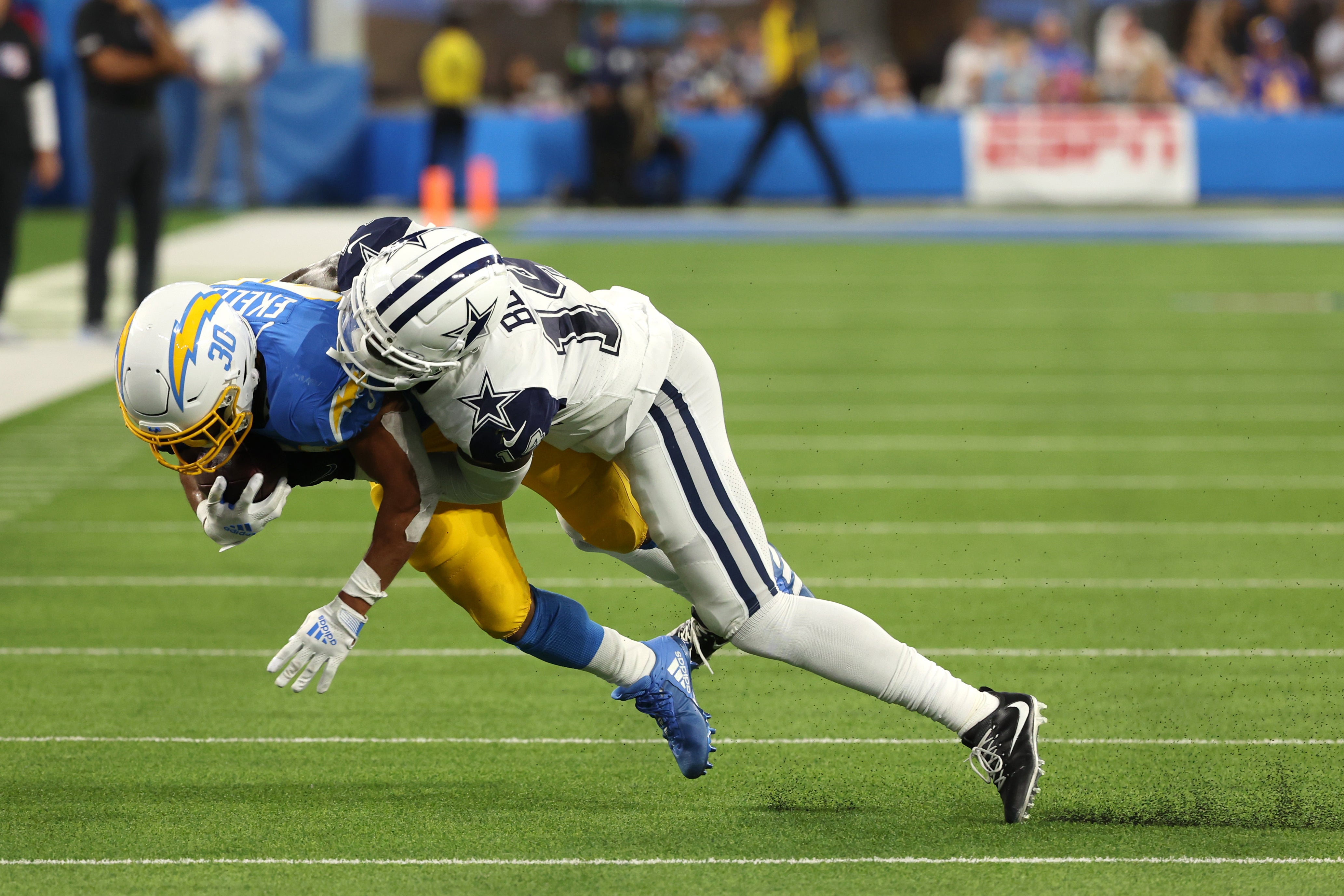 Dallas Cowboys safety Markquese Bell (14) tackles Los Angeles Chargers running back Austin Ekeler (30) during the third quarter at SoFi Stadium.