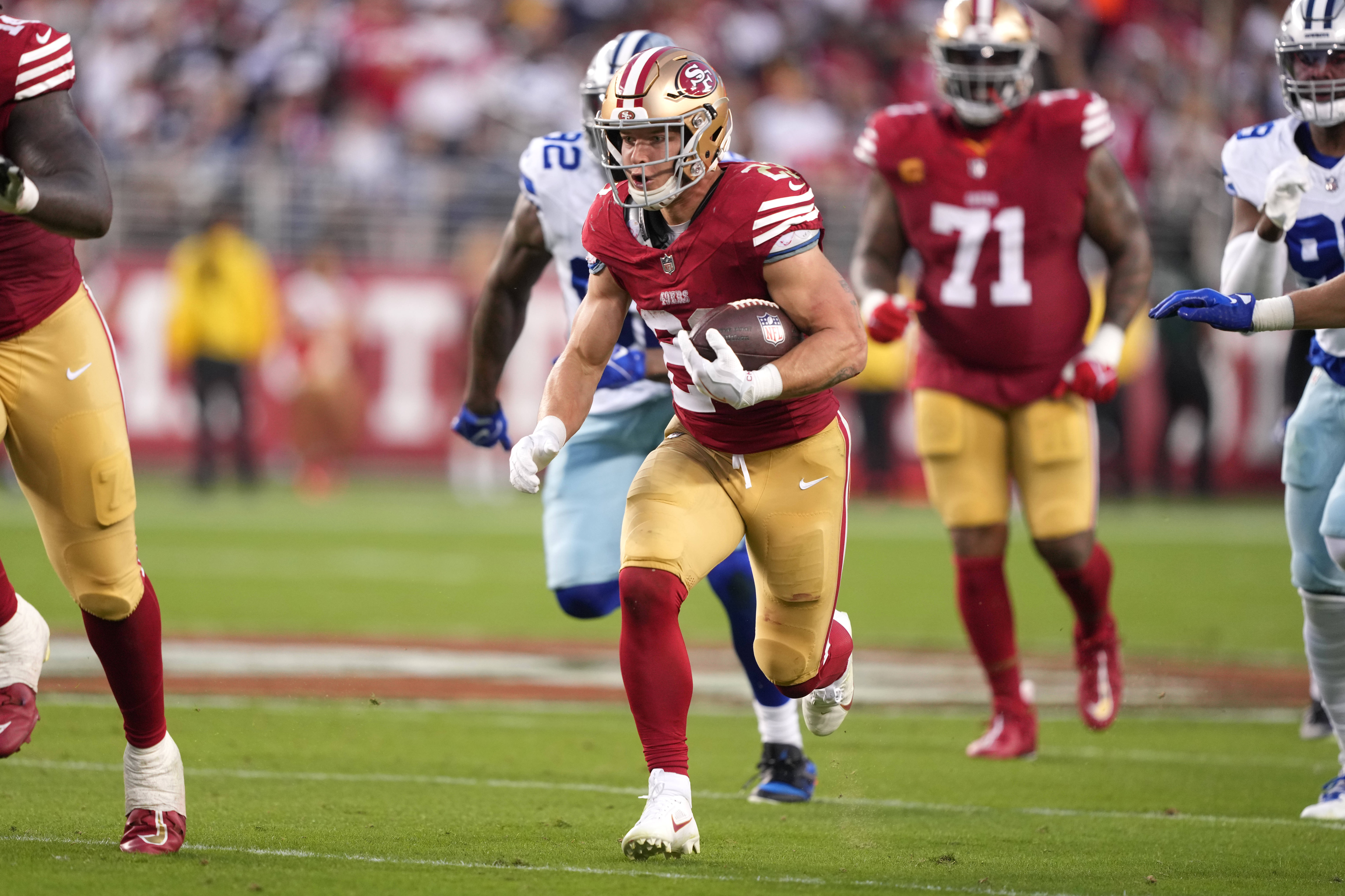 Oct 8, 2023; Santa Clara, California, USA; San Francisco 49ers running back Christian McCaffrey (center) carries the ball against the Dallas Cowboys during the second quarter at Levi's Stadium.