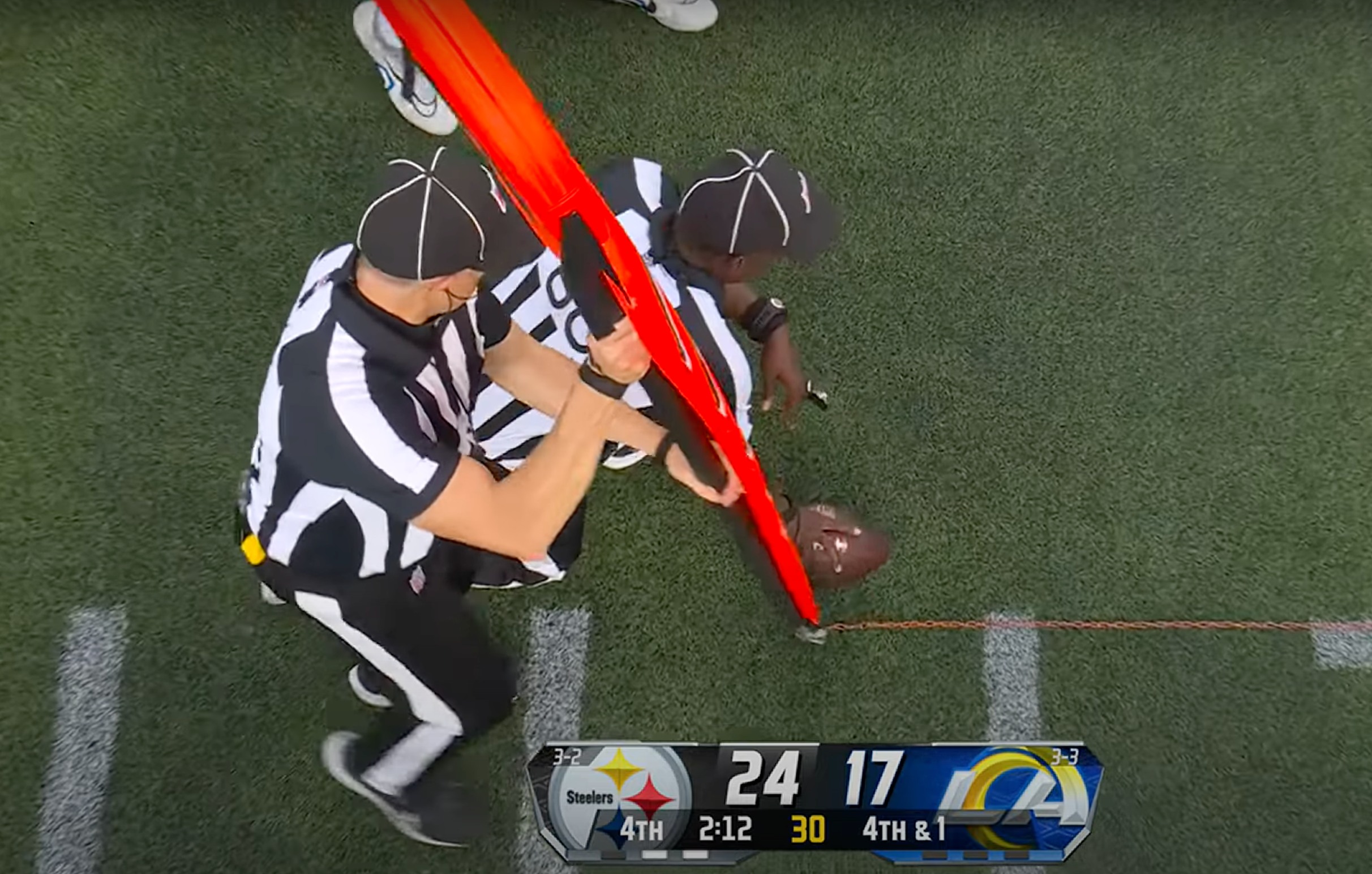 Officials measure the spot of the ball during the Rams-Steelers game.