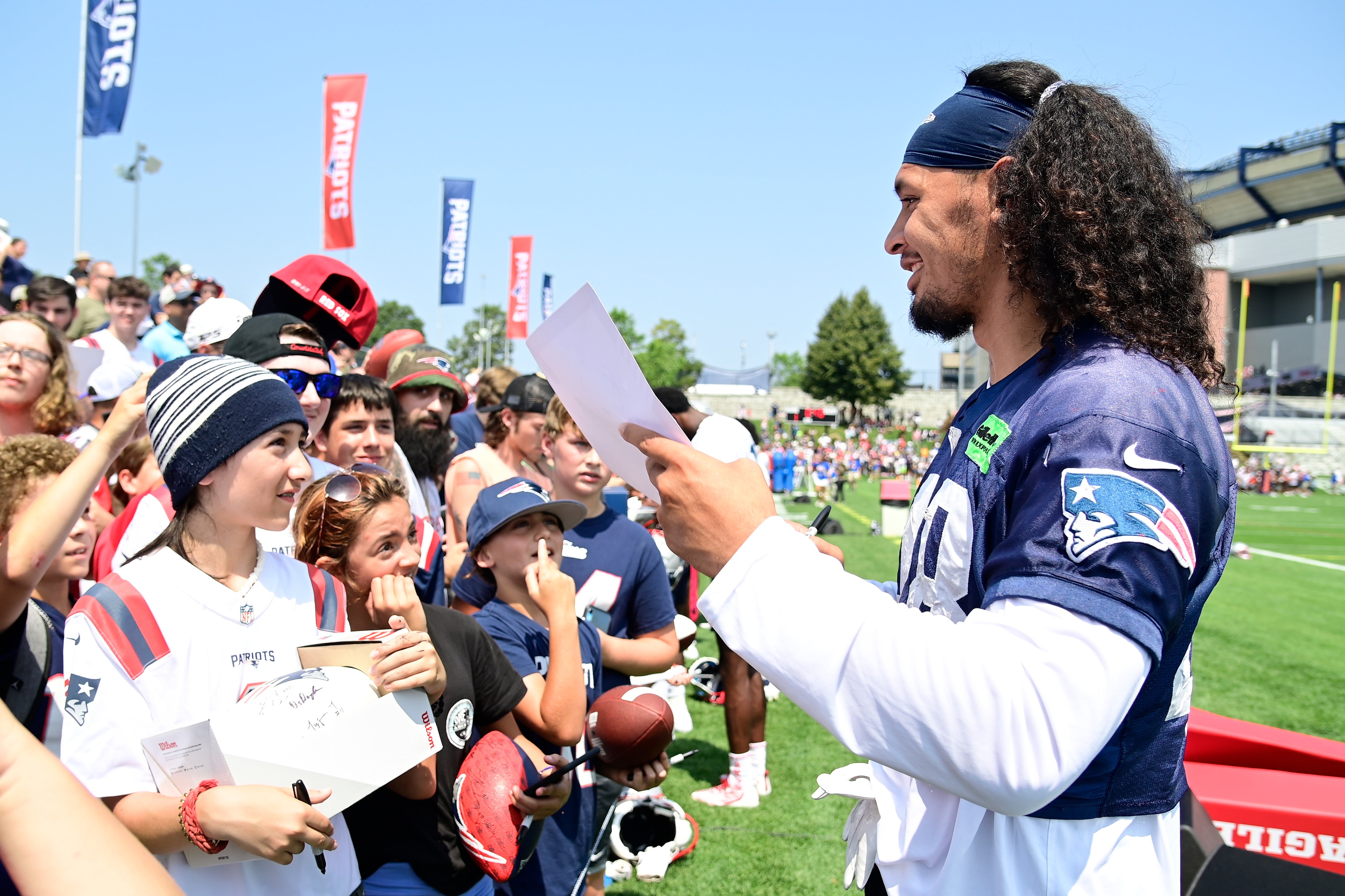 Jahlani Tavai signs autographs for fans during Patriots training camp