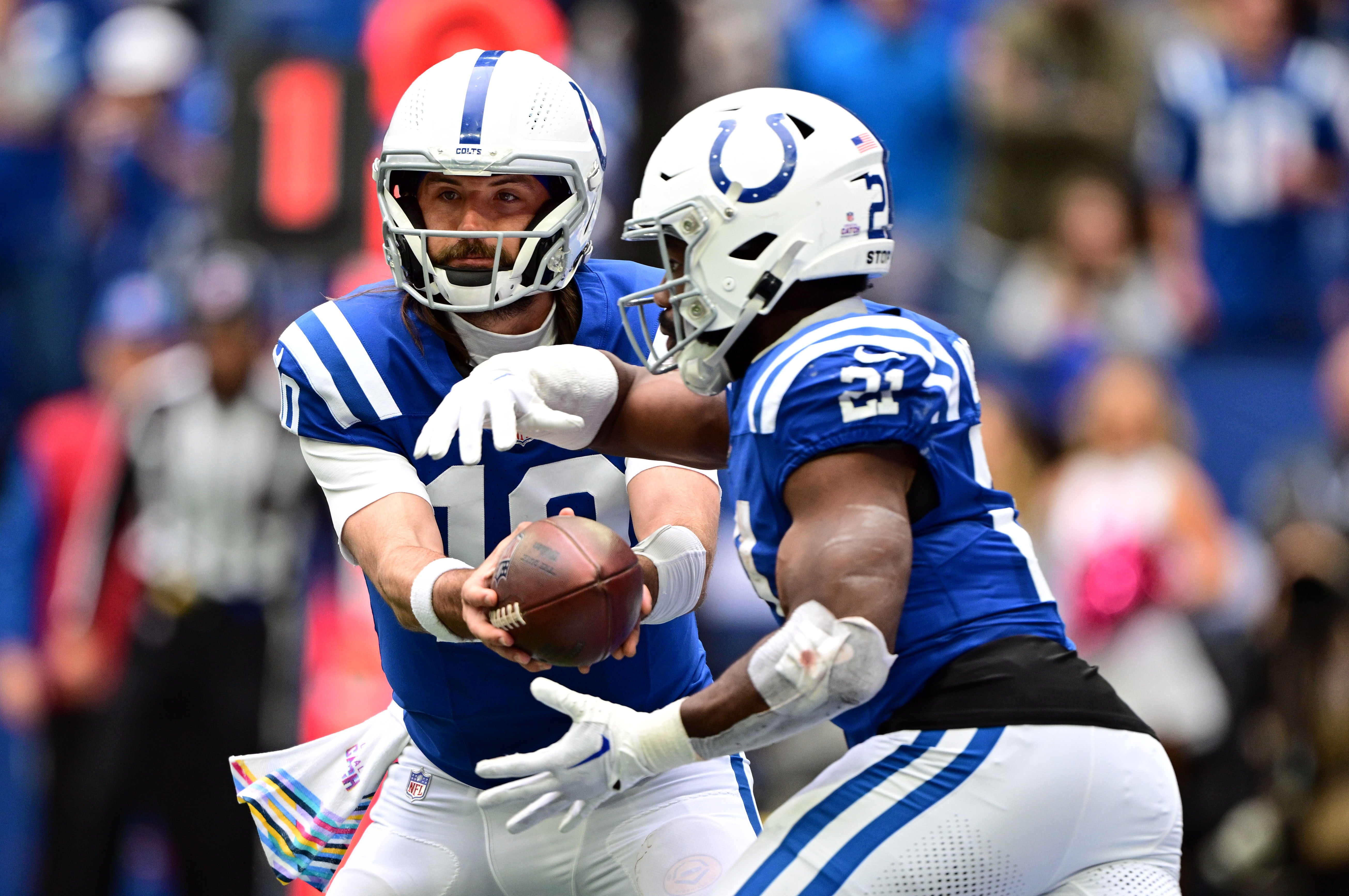 Oct 8, 2023; Indianapolis, Indiana, USA; Indianapolis Colts quarterback Gardner Minshew (10) hands the ball off to Indianapolis Colts running back Zack Moss (21) during the second half against the Tennessee Titans at Lucas Oil Stadium.