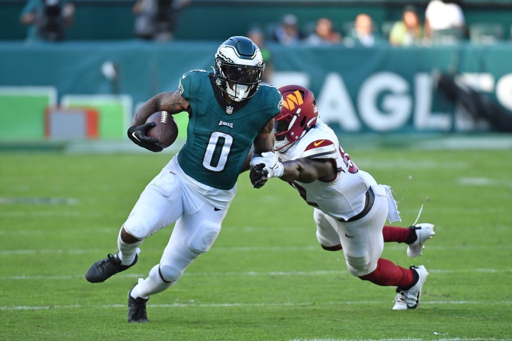 Eagles running back D'Andre Swift avoids being tackled by Commanders' Jamin Davis