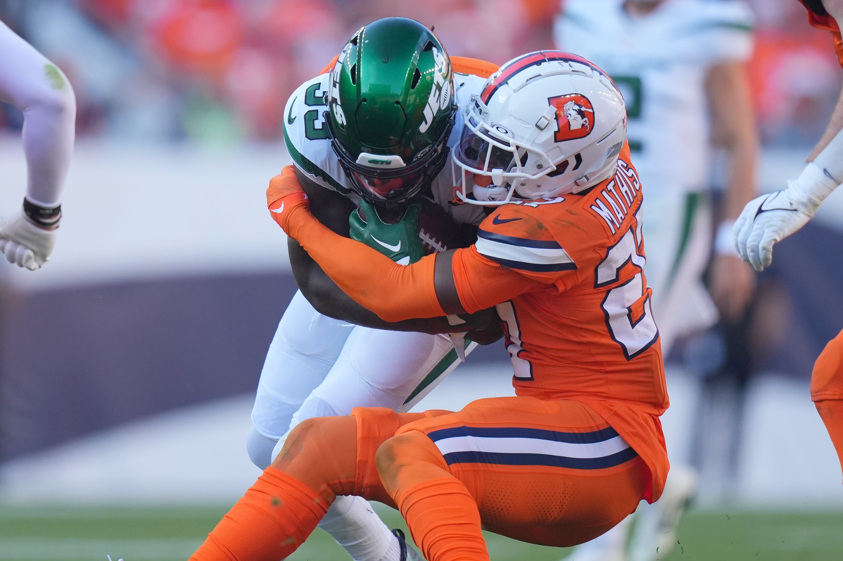 Denver Broncos cornerback Damarri Mathis (27) tackles New York Jets running back Dalvin Cook (33) in the second half at Empower Field at Mile High.