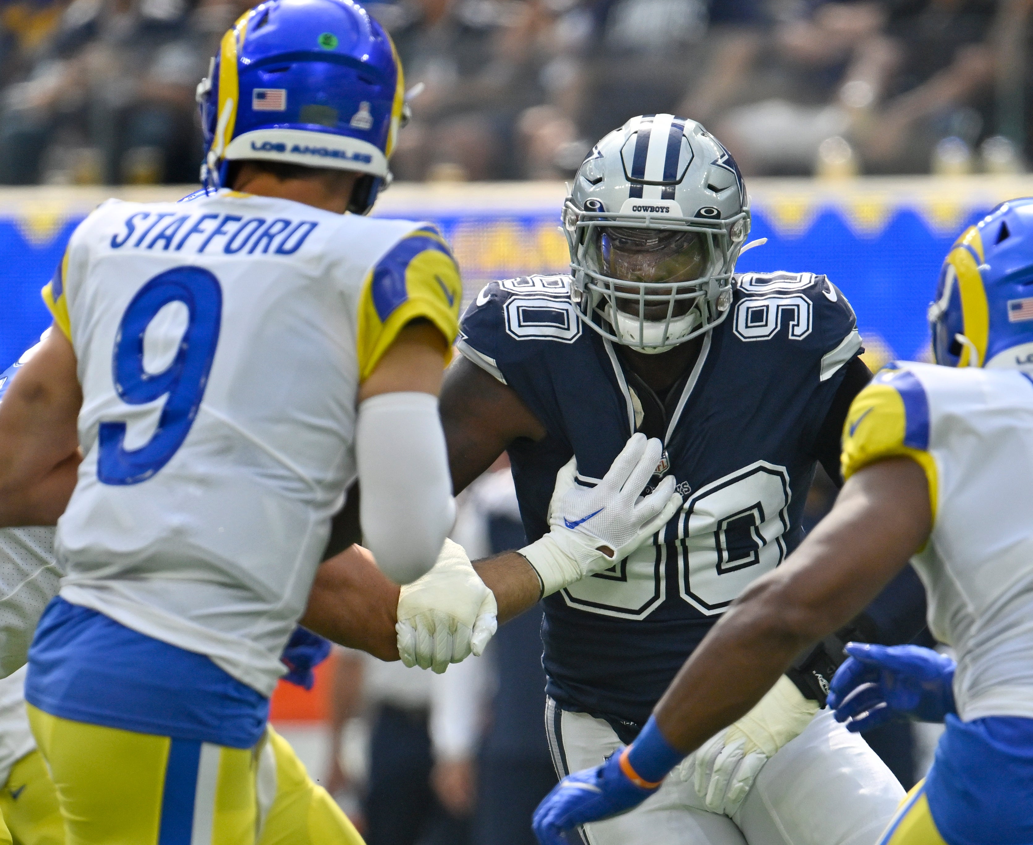 Dallas Cowboys defensive end DeMarcus Lawrence (90) pressures Los Angeles Rams quarterback Matthew Stafford (9) during the first quarter at SoFi Stadium.