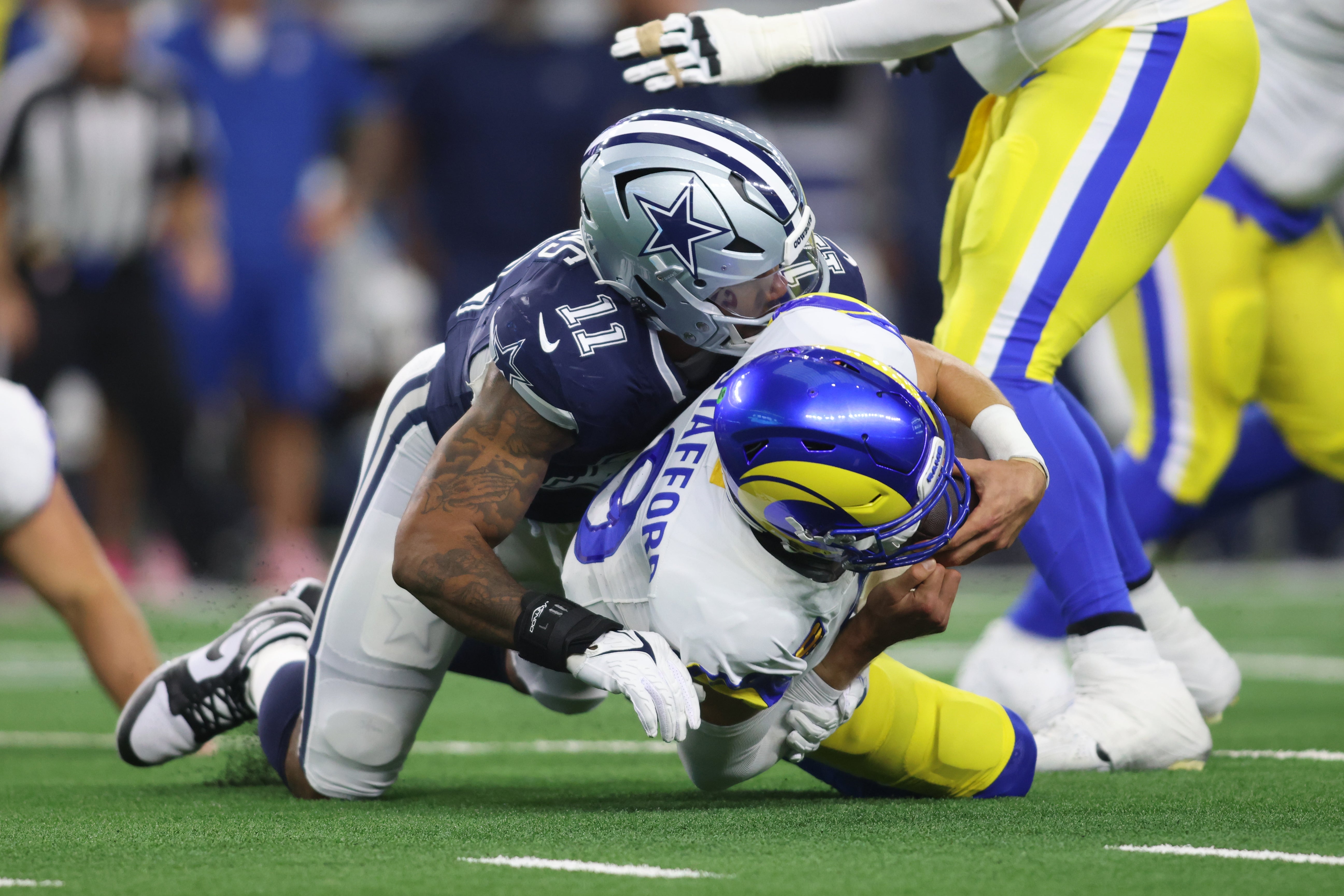 Los Angeles Rams quarterback Matthew Stafford (9) is sacked by Dallas Cowboys linebacker Micah Parsons (11) in the second quarter at AT&T Stadium.
