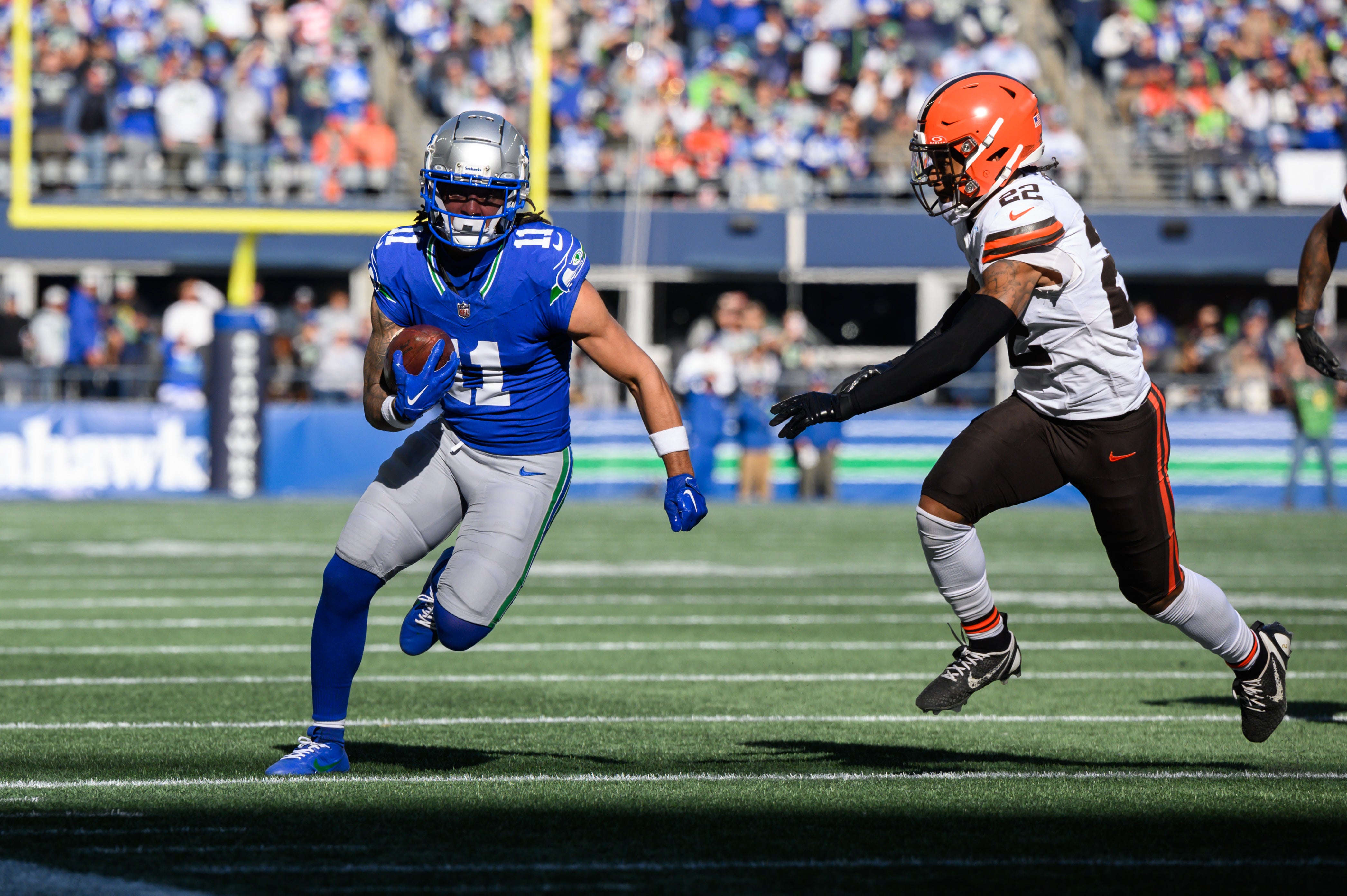 Oct 29, 2023; Seattle, Washington, USA; Seattle Seahawks wide receiver Jaxon Smith-Njigba (11) carries the ball after a catch while chased by Cleveland Browns safety Grant Delpit (22) at Lumen Field. Mandatory Credit: Steven Bisig-USA TODAY Sports