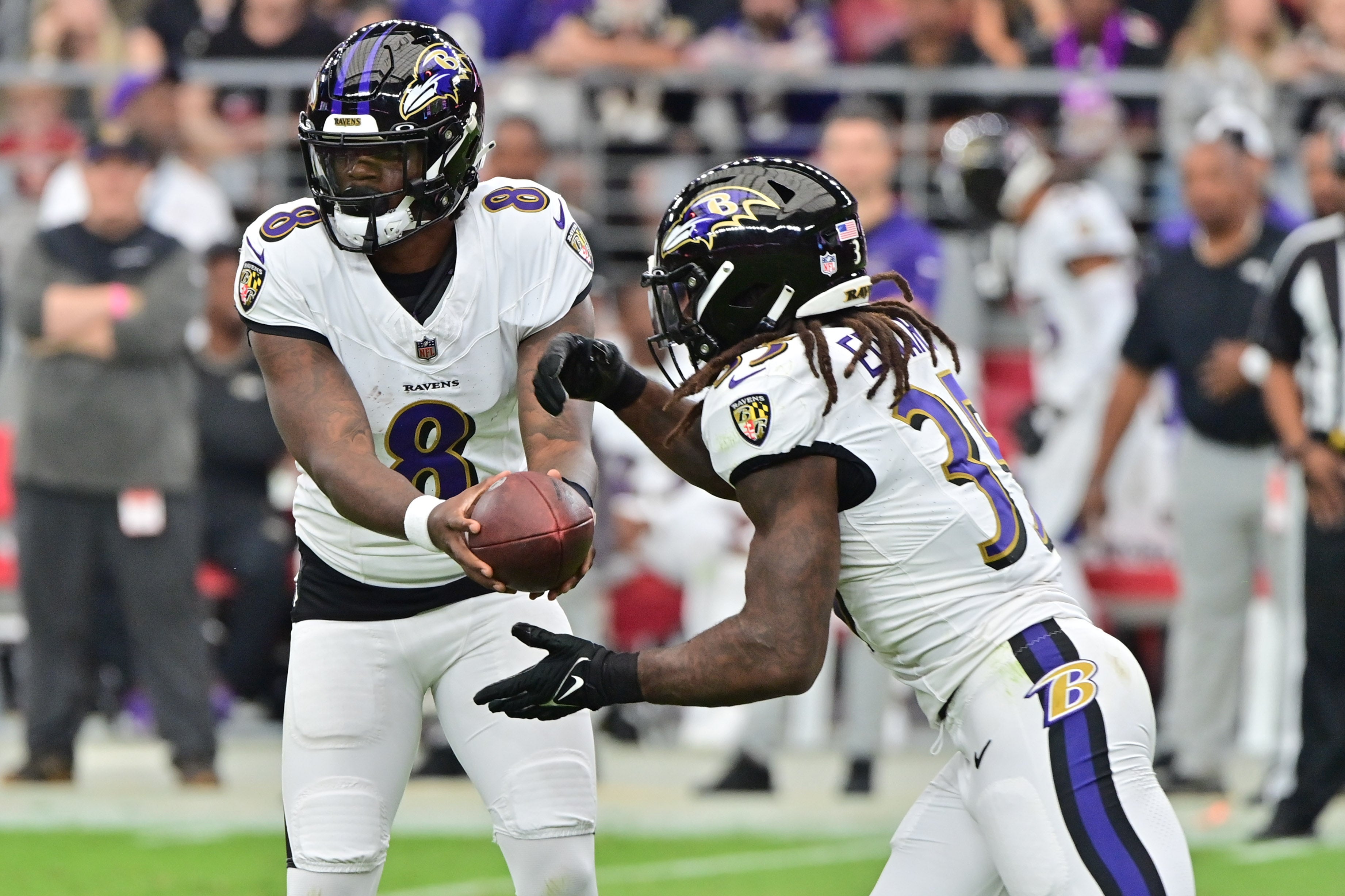 Baltimore Ravens quarterback Lamar Jackson (8) hands off to running back Gus Edwards (35) in the first half against the Arizona Cardinals at State Farm Stadium.