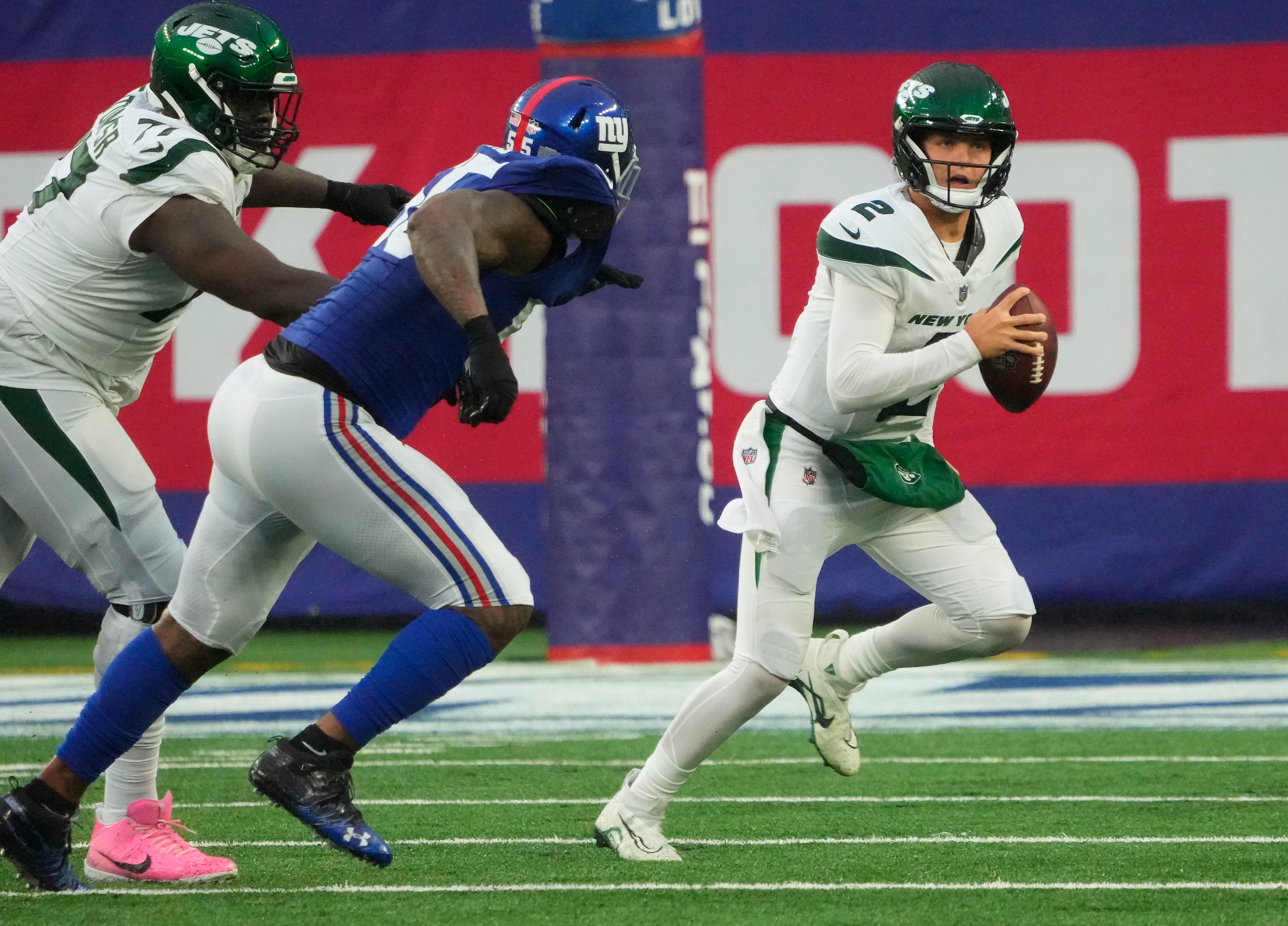 New York Jets quarterback Zach Wilson (2) gets past New York Giants linebacker Jihad Ward (55) in the second half at MetLife Stadium.