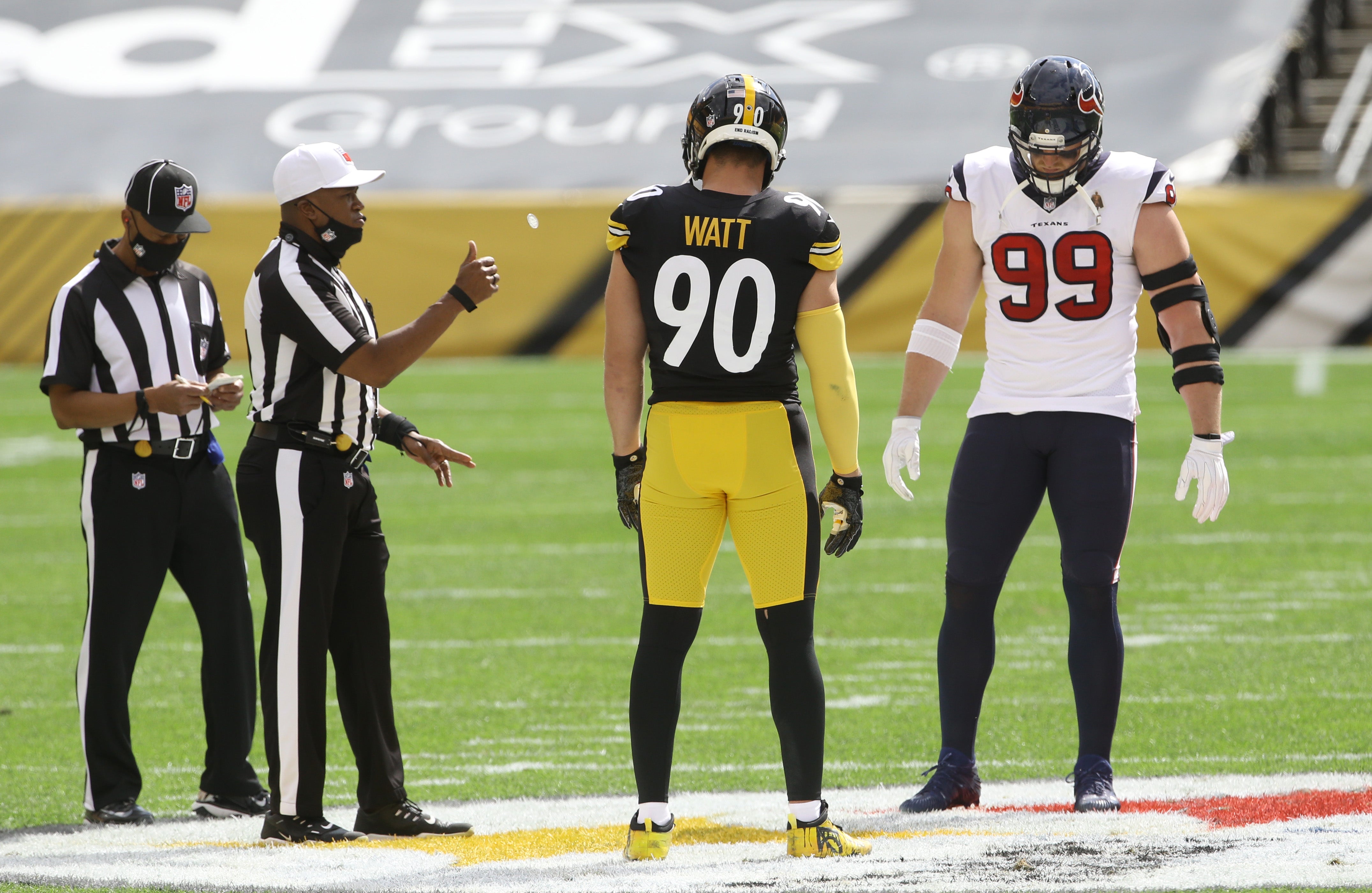 Sep 27, 2020; Pittsburgh, Pennsylvania, USA; NFL referee Shawn Smith (14) flips the coin as brothers Pittsburgh Steelers outside linebacker T.J. Watt (90) and Houston Texans defensive end J.J. Watt (99) take part before their game against at Heinz Field. The Steelers won 28-21. Mandatory Credit: Charles LeClaire-USA TODAY Sports