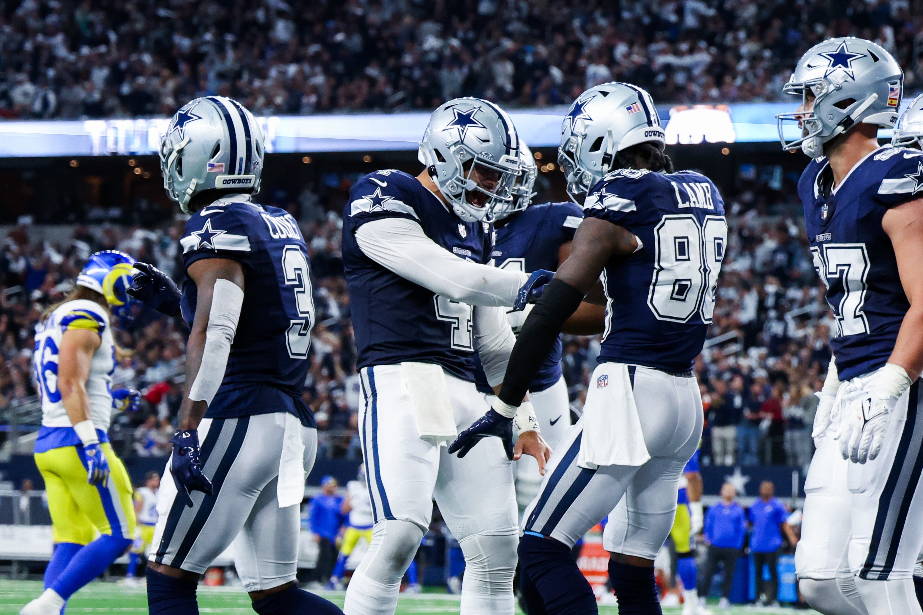 Dallas Cowboys wide receiver CeeDee Lamb (88) celebrates with Dallas Cowboys quarterback Dak Prescott (4) after catching a touchdown pass during the first half against the Los Angeles Rams at AT&T Stadium.