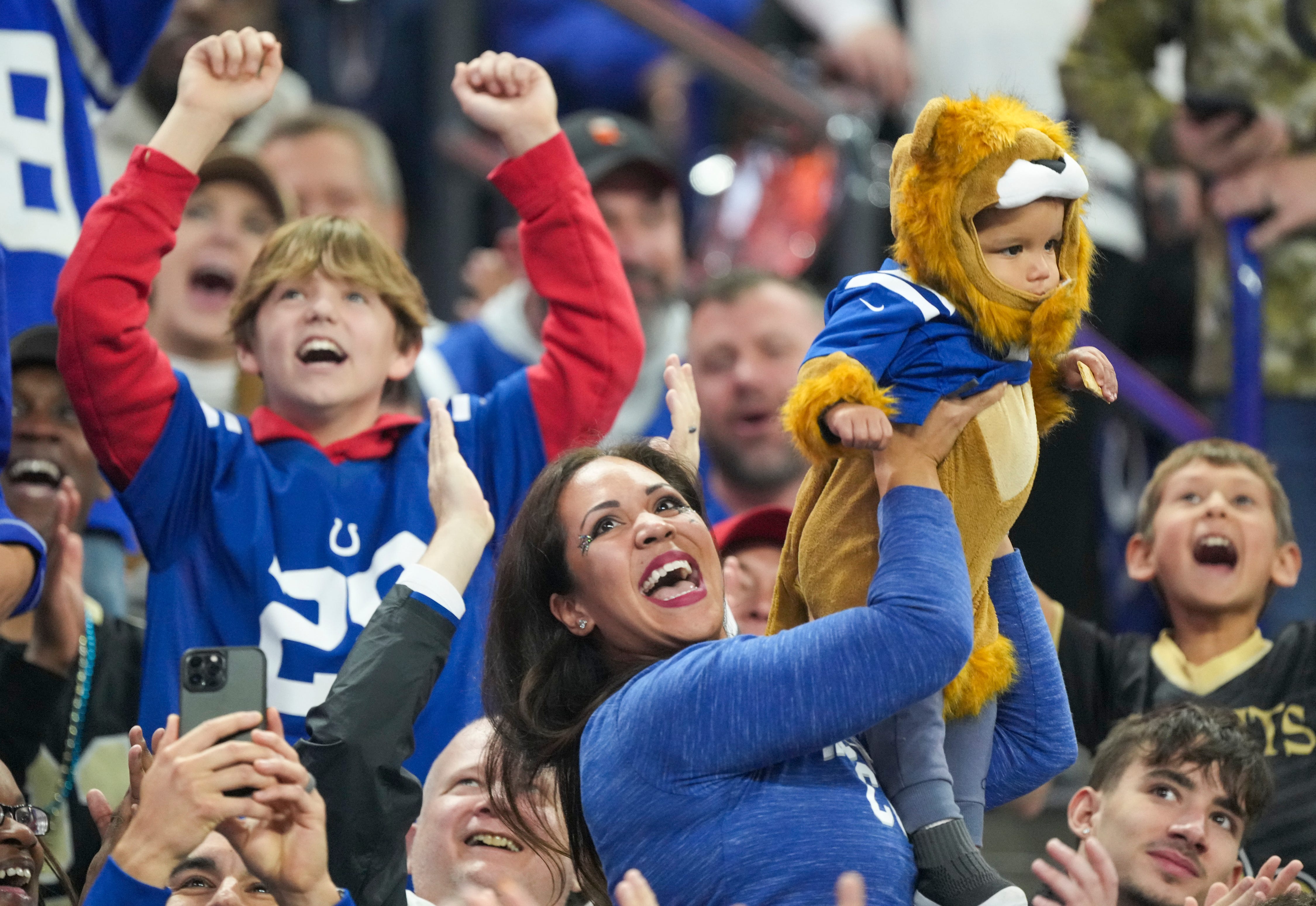 A baby is held up to cheers from fans during a Lion King-themed fan participation spot during a timeout, Sunday., Oct 29, 2023, at Lucas Oil Stadium in Indianapolis.