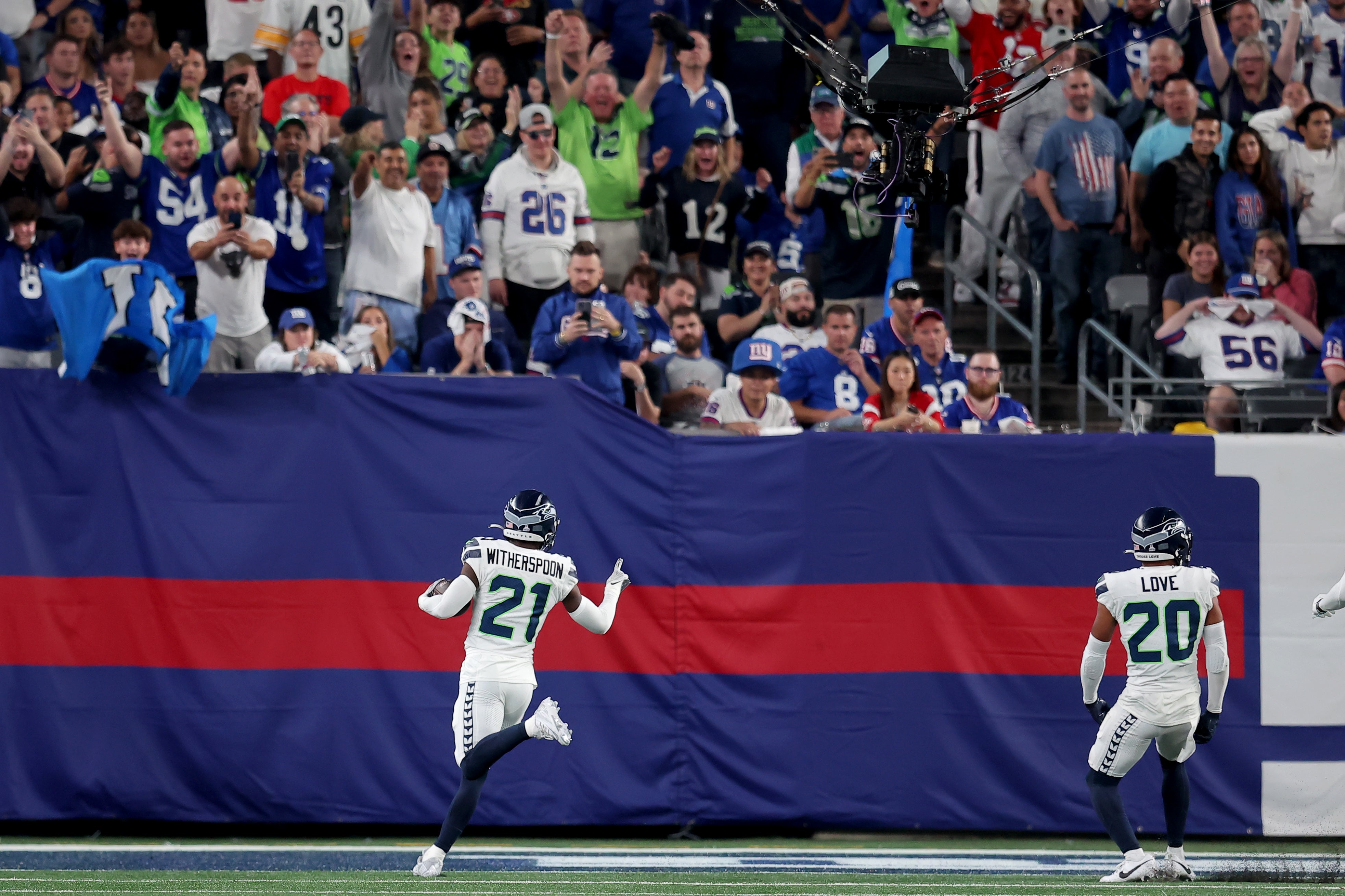 Oct 2, 2023; East Rutherford, New Jersey, USA; Seattle Seahawks cornerback Devon Witherspoon (21) celebrates his interception for a touchdown during the third quarter against the New York Giants at MetLife Stadium. Mandatory Credit: Brad Penner-USA TODAY Sports