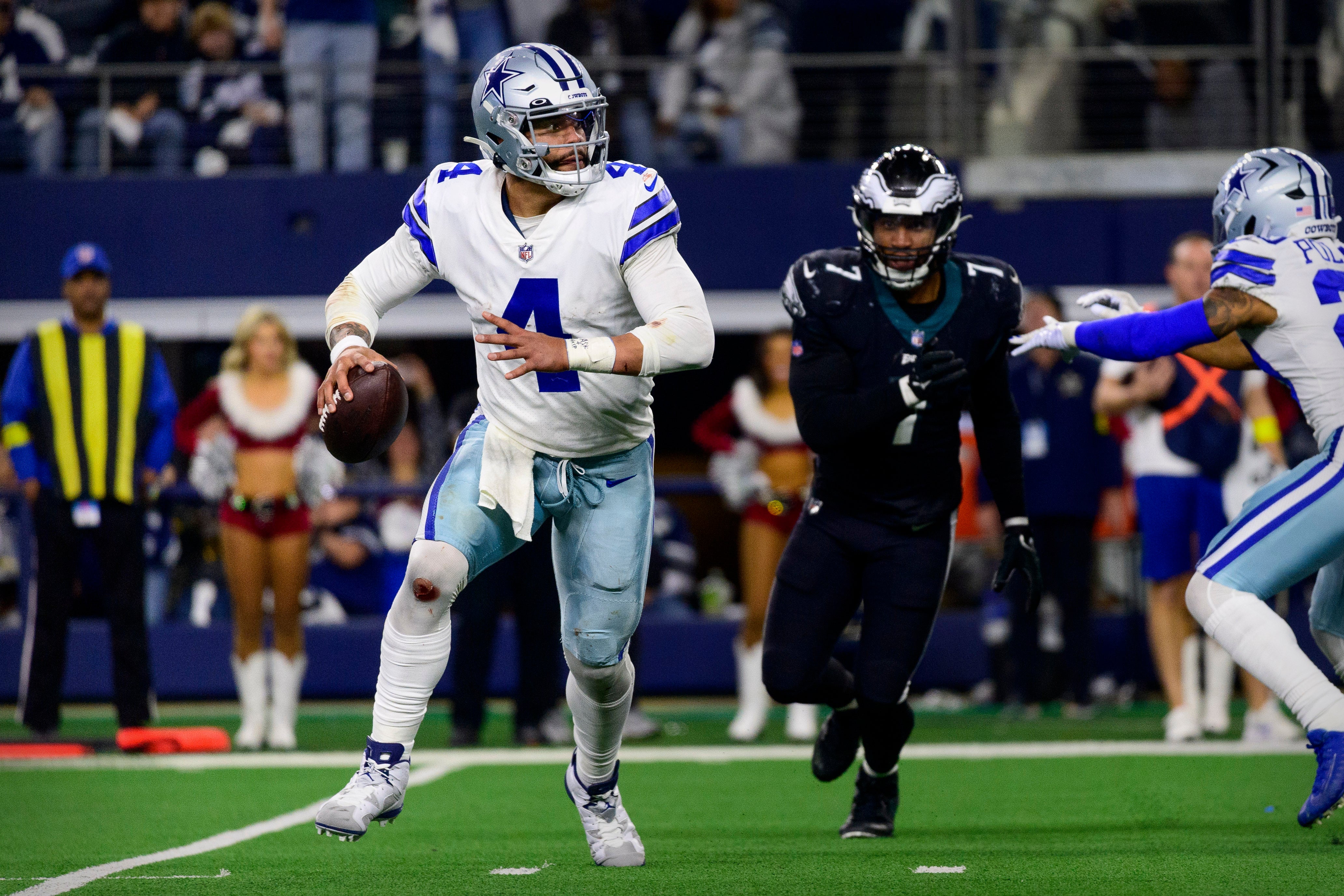 Dallas Cowboys quarterback Dak Prescott (4) rolls out to avoid the rush by Philadelphia Eagles linebacker Haason Reddick (7) during the second half at AT&T Stadium.