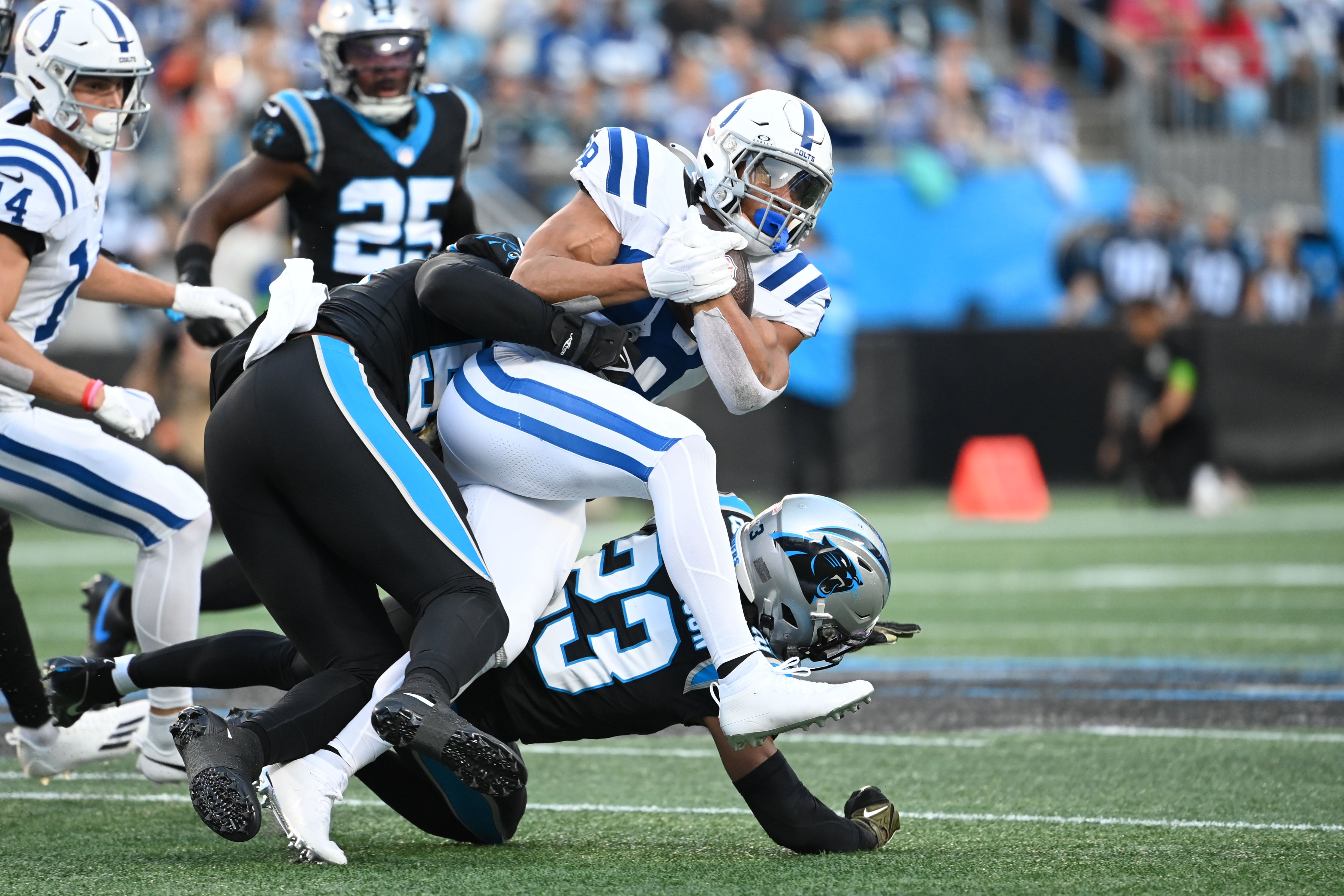 Nov 5, 2023; Charlotte, North Carolina, USA; Indianapolis Colts running back Jonathan Taylor (28) runs as Carolina Panthers linebacker DJ Johnson (52) and cornerback CJ Henderson (23) defend in the first quarter at Bank of America Stadium. Mandatory Credit: Bob Donnan-USA TODAY Sports