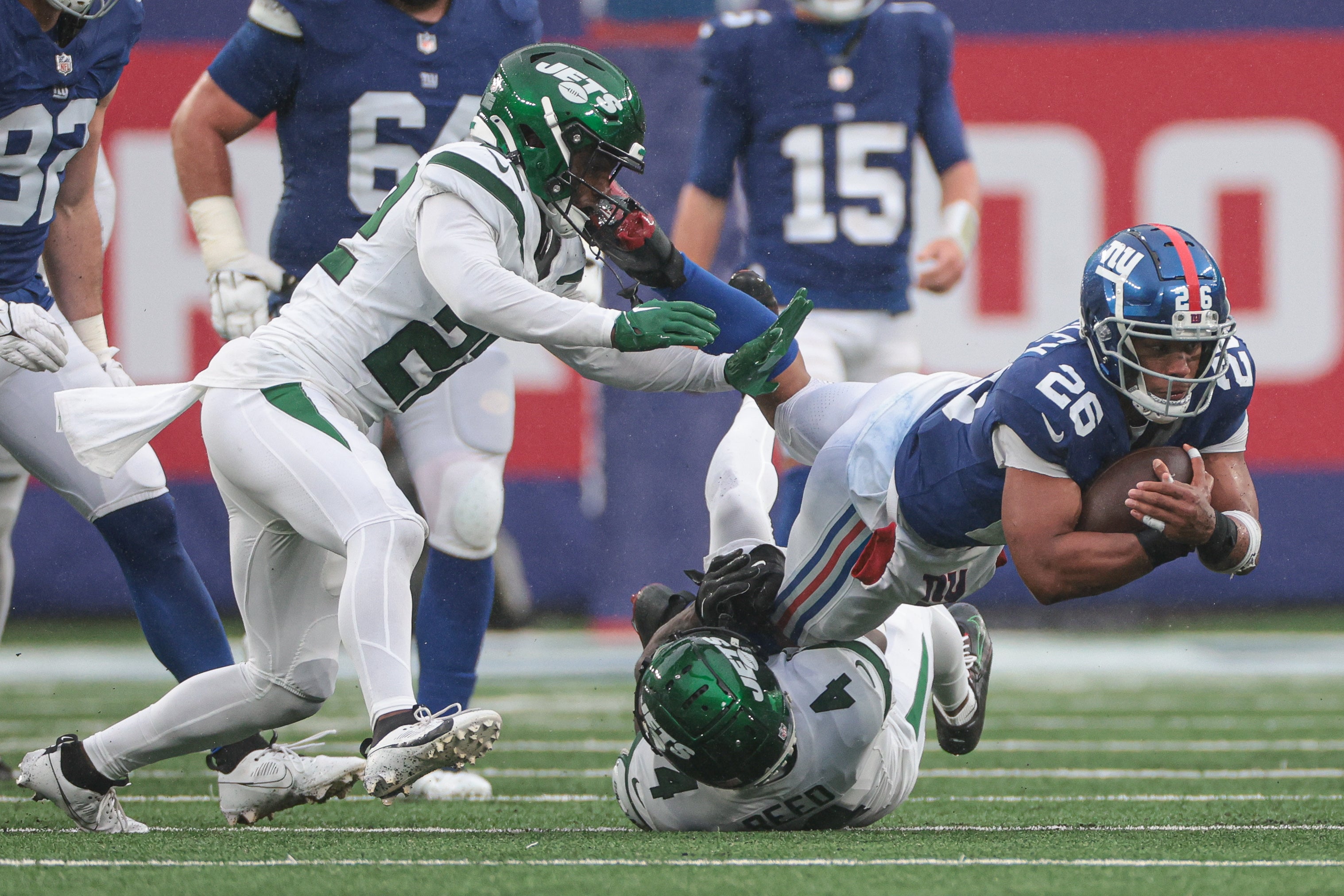 New York Giants running back Saquon Barkley (26) is tackled by New York Jets cornerback D.J. Reed (4) as safety Tony Adams (22) pursues during the second half at MetLife Stadium.