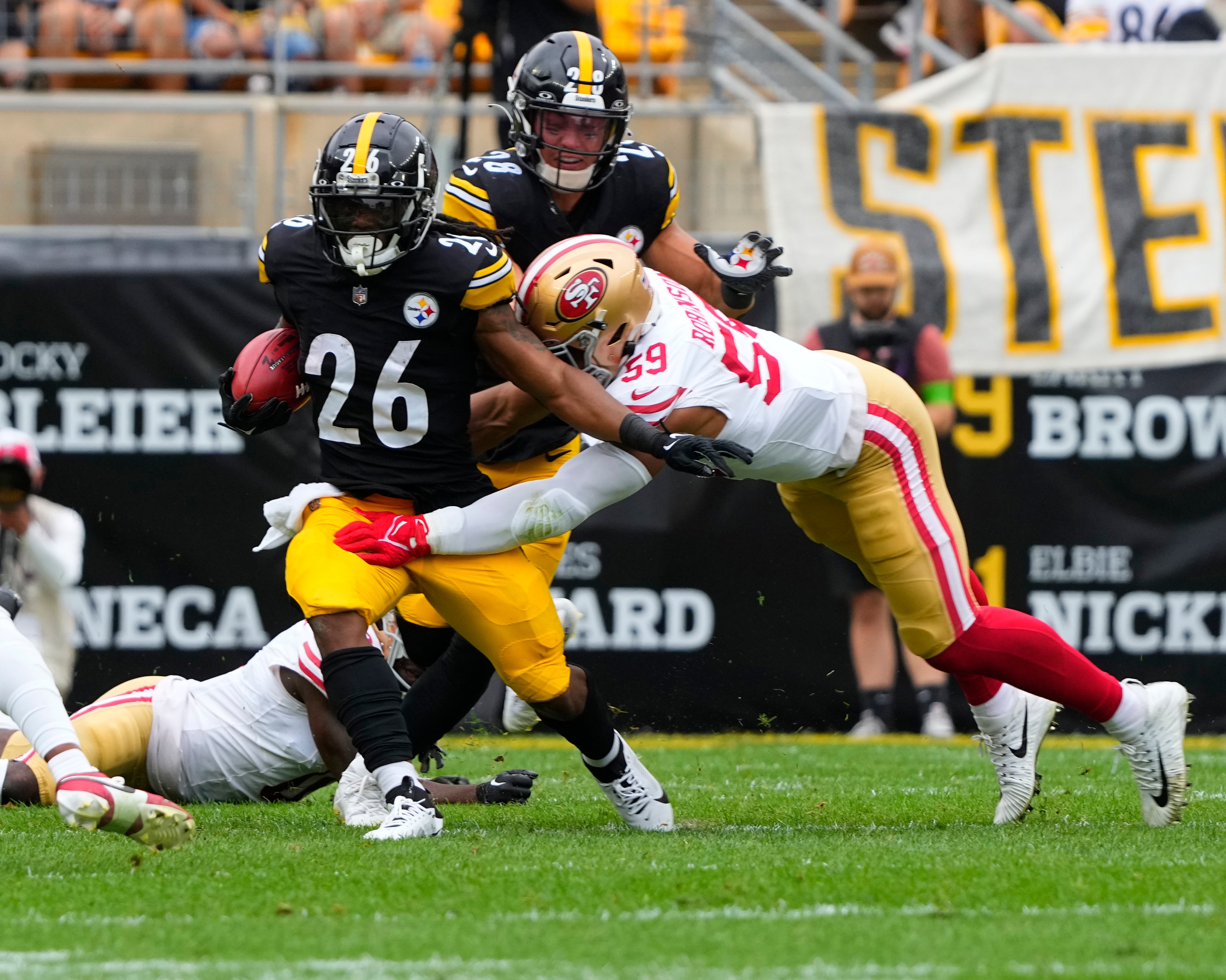 Sep 10, 2023; Pittsburgh, Pennsylvania, USA; Pittsburgh Steelers running back Anthony McFarland Jr. (26) runs with the ball and is tackled by San Francisco 49ers linebacker Curtis Robinson (59) during the first half at Acrisure Stadium. Mandatory Credit: Gregory Fisher-USA TODAY Sports  