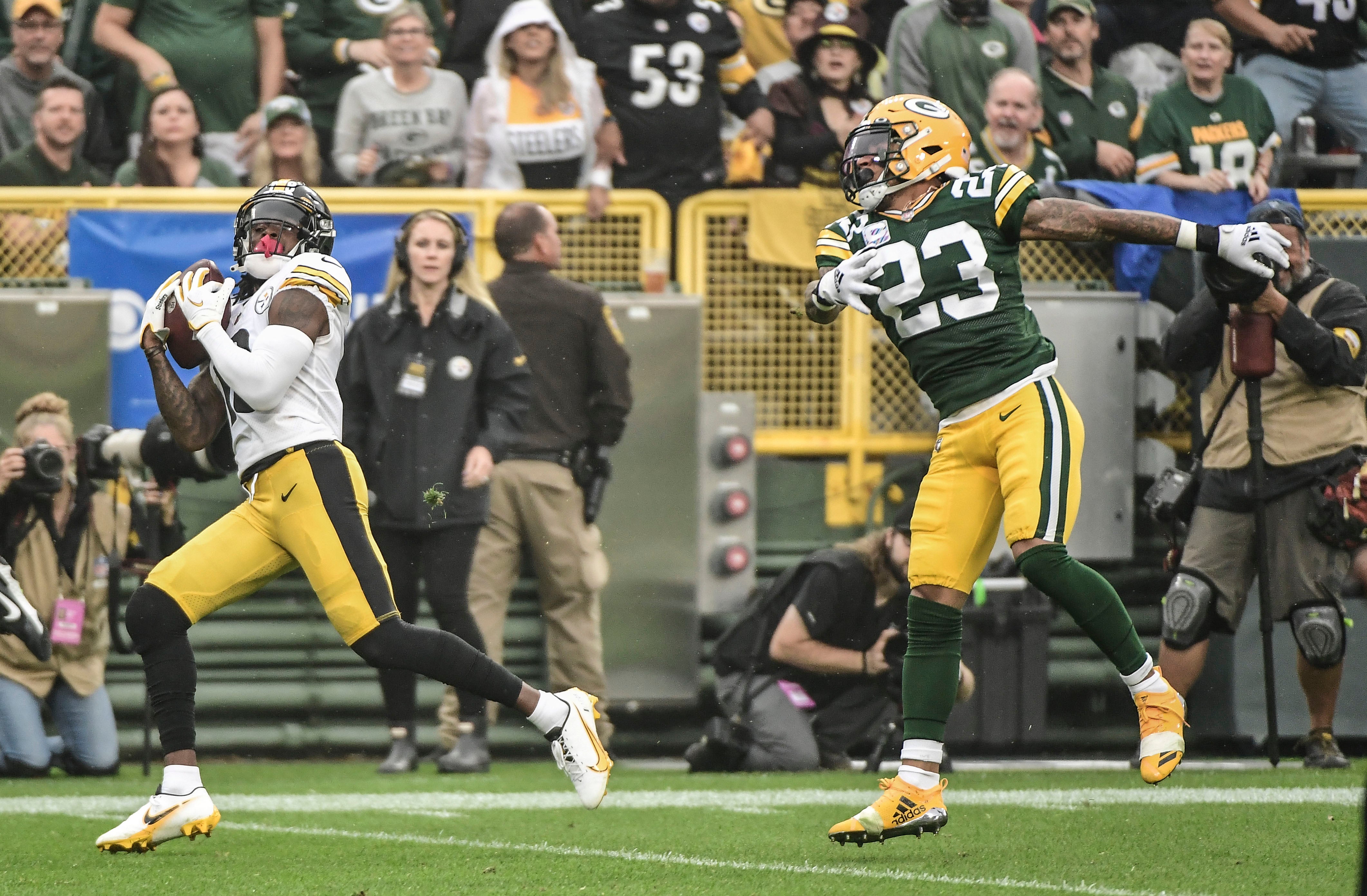 Oct 3, 2021; Green Bay, Wisconsin, USA; Pittsburgh Steelers wide receiver Diontae Johnson (18) catches a touchdown pass against Green Bay Packers cornerback Jaire Alexander (23) in the first quarter at Lambeau Field. Mandatory Credit: Benny Sieu-USA TODAY Sports