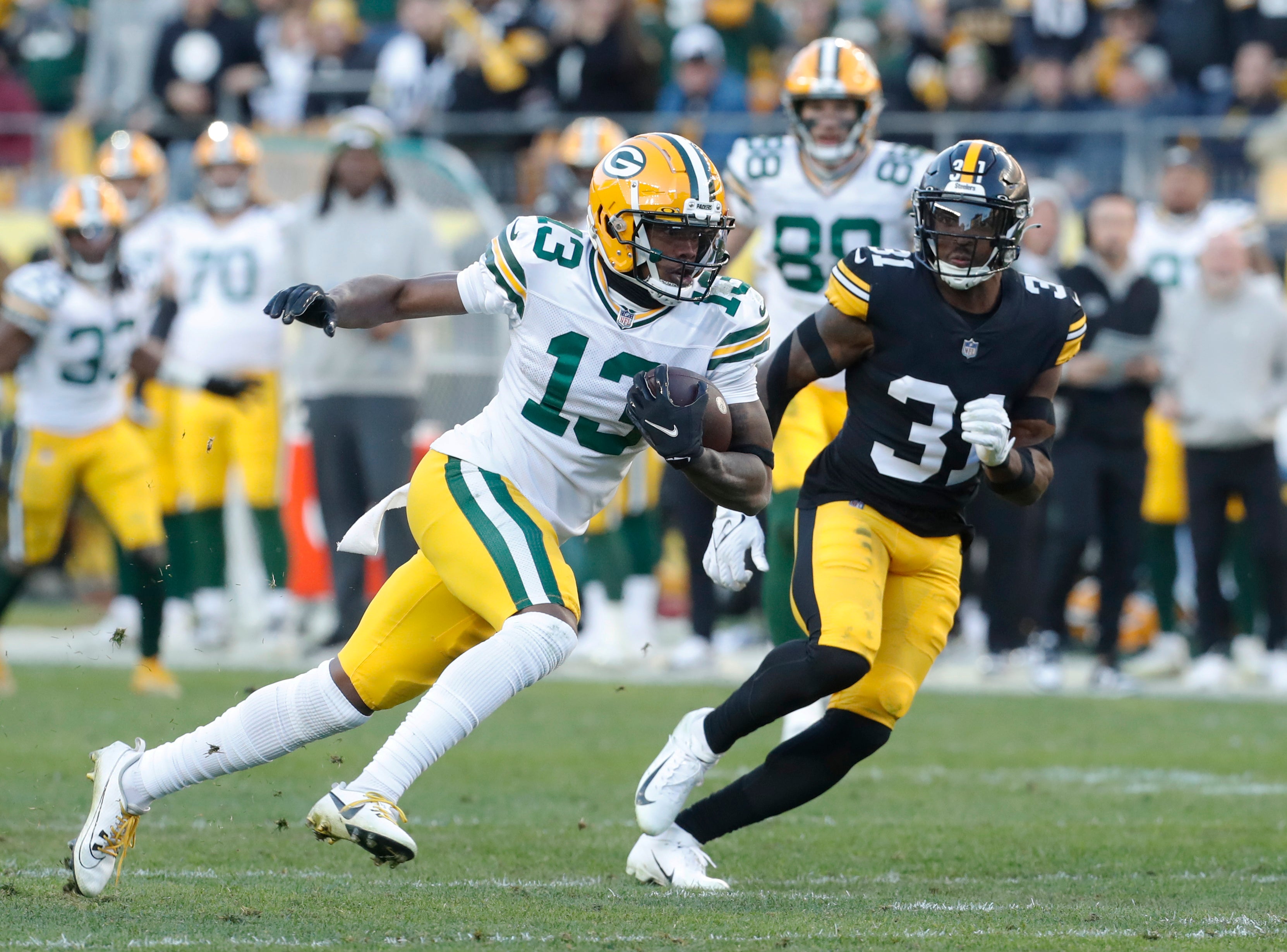 Nov 12, 2023; Pittsburgh, Pennsylvania, USA; Green Bay Packers wide receiver Dontayvion Wicks (13) runs after a catch as Pittsburgh Steelers safety Keanu Neal (31) chases during the fourth quarter at Acrisure Stadium. Pittsburgh won 23-19. Mandatory Credit: Charles LeClaire-USA TODAY Sports  