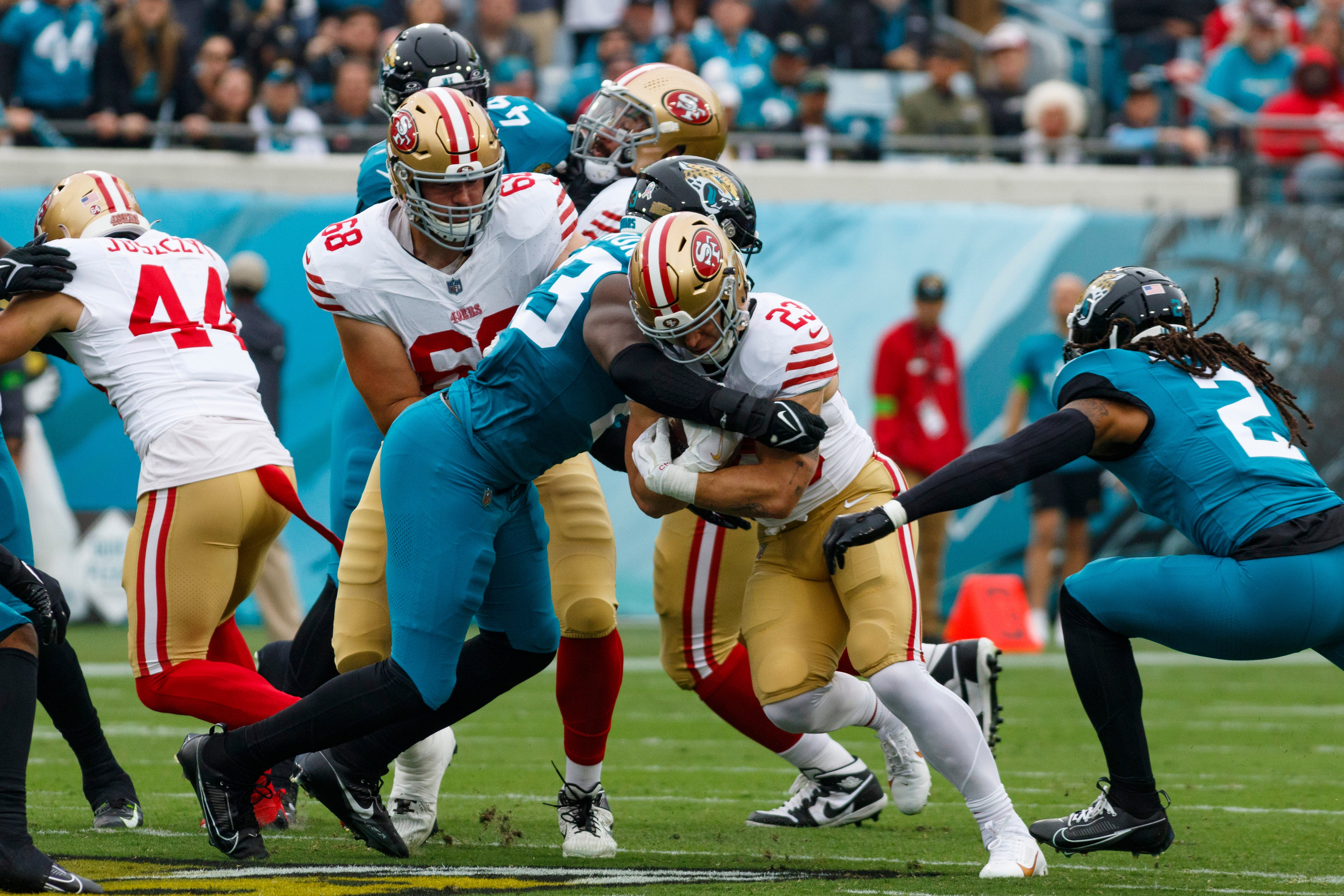 Nov 12, 2023; Jacksonville, Florida, USA; Jacksonville Jaguars offensive lineman Blake Hance (73) and safety Rayshawn Jenkins (2) tackle San Francisco 49ers running back Christian McCaffrey (23) with offensive tackle Colton McKivitz (68) blocking during the first quarter at EverBank Stadium.