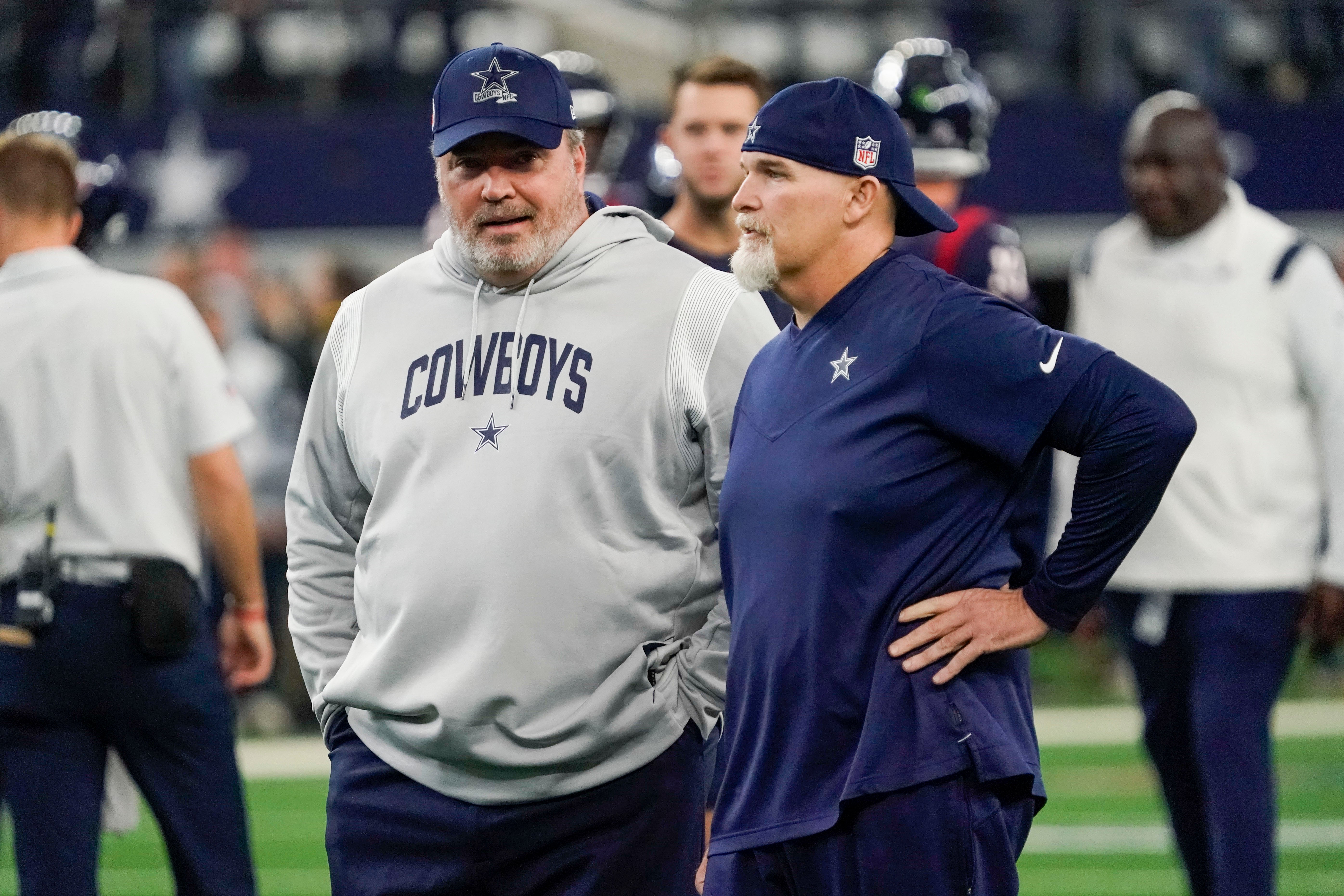 Dallas Cowboys head coach Mike McCarthy and defensive coordinator Dan Quinn talk at midfield prior to a game against the Houston Texans at AT&T Stadium.
