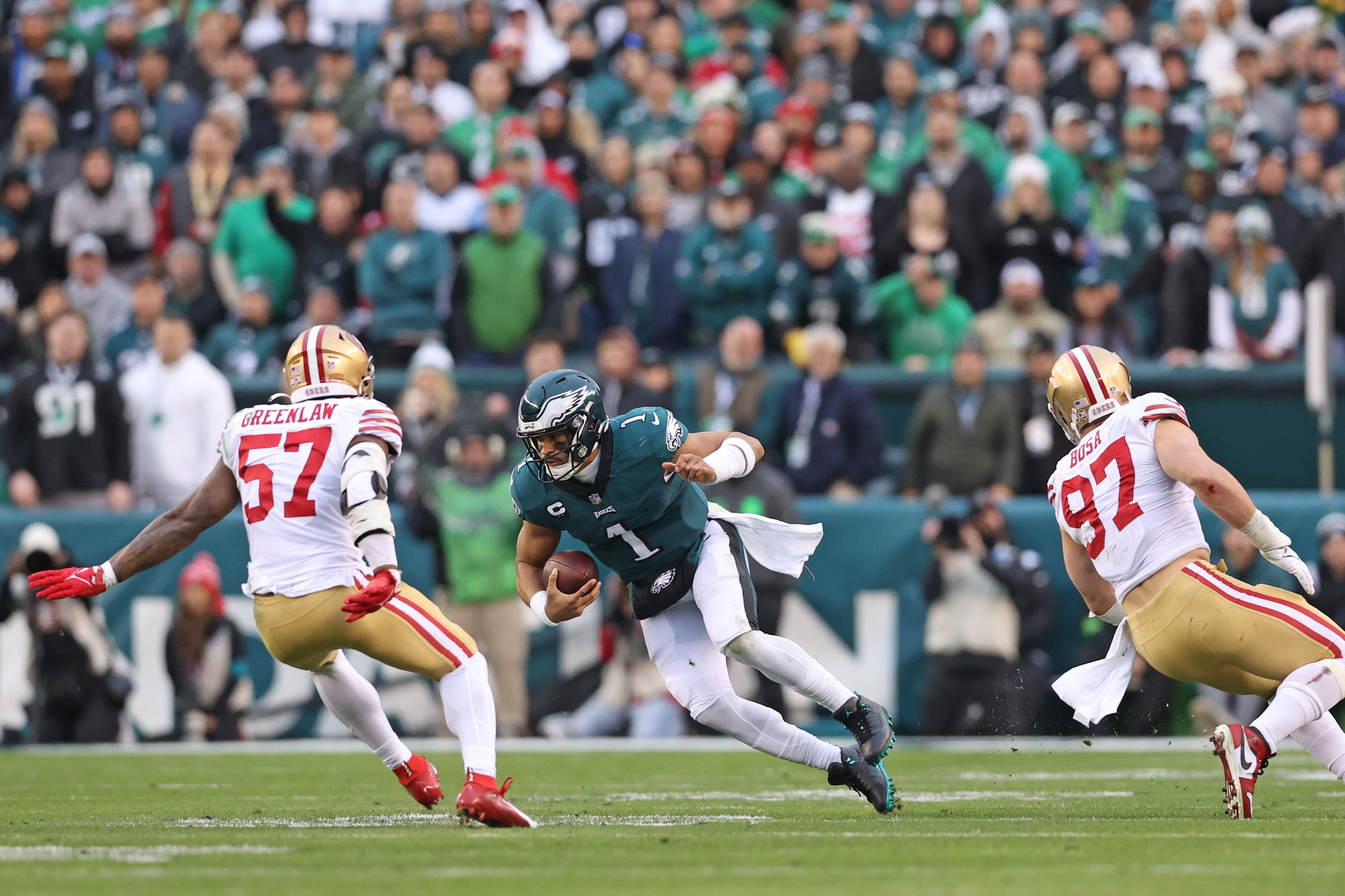 Jan 29, 2023; Philadelphia, Pennsylvania, USA; Philadelphia Eagles quarterback Jalen Hurts (1) ties to avoid San Francisco 49ers linebacker Dre Greenlaw (57) and defensive end Nick Bosa (97) during the second quarter in the NFC Championship game at Lincoln Financial Field.
