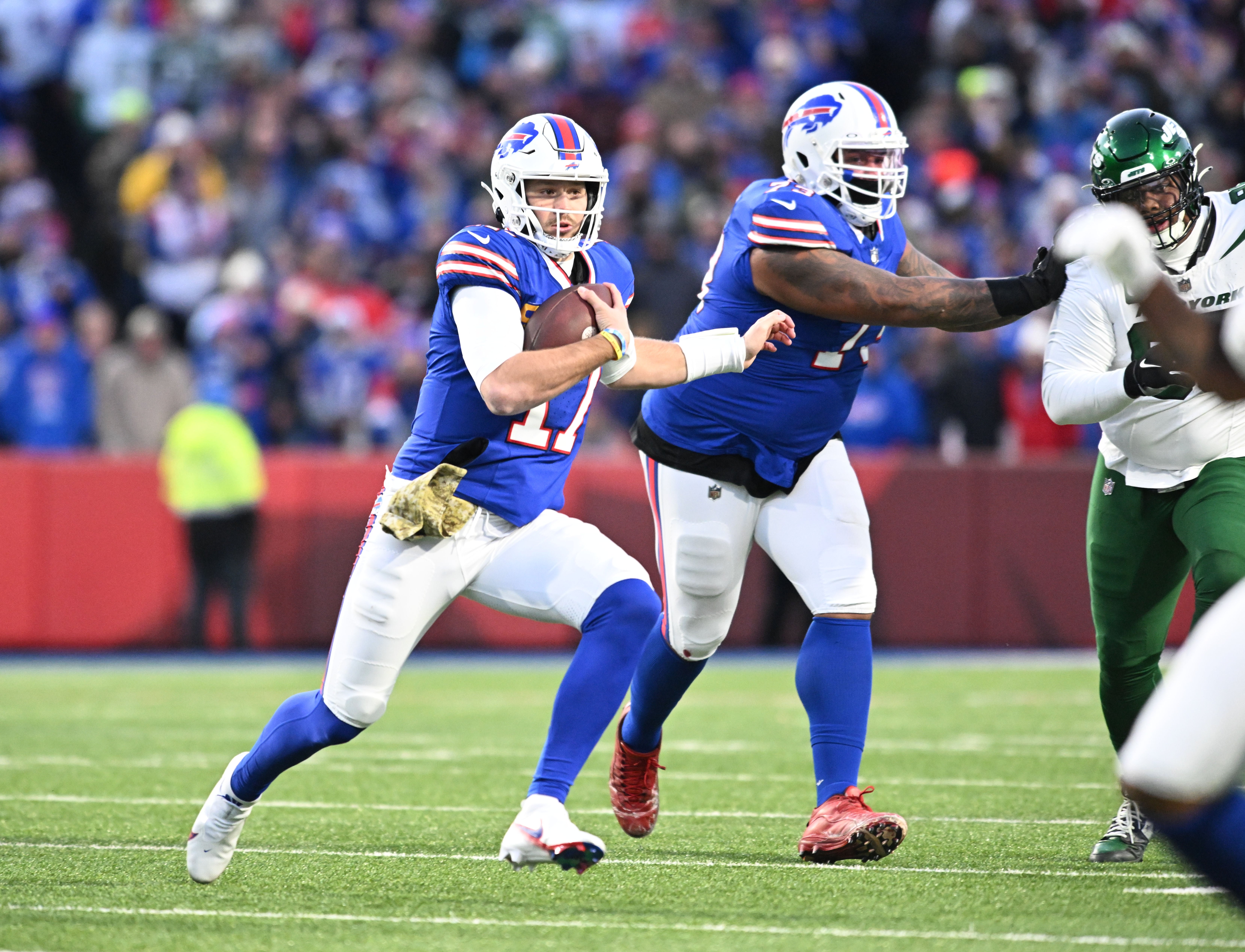 Buffalo Bills quarterback Josh Allen (17) runs for a first down against the New York Jets in the first quarter at Highmark Stadium.