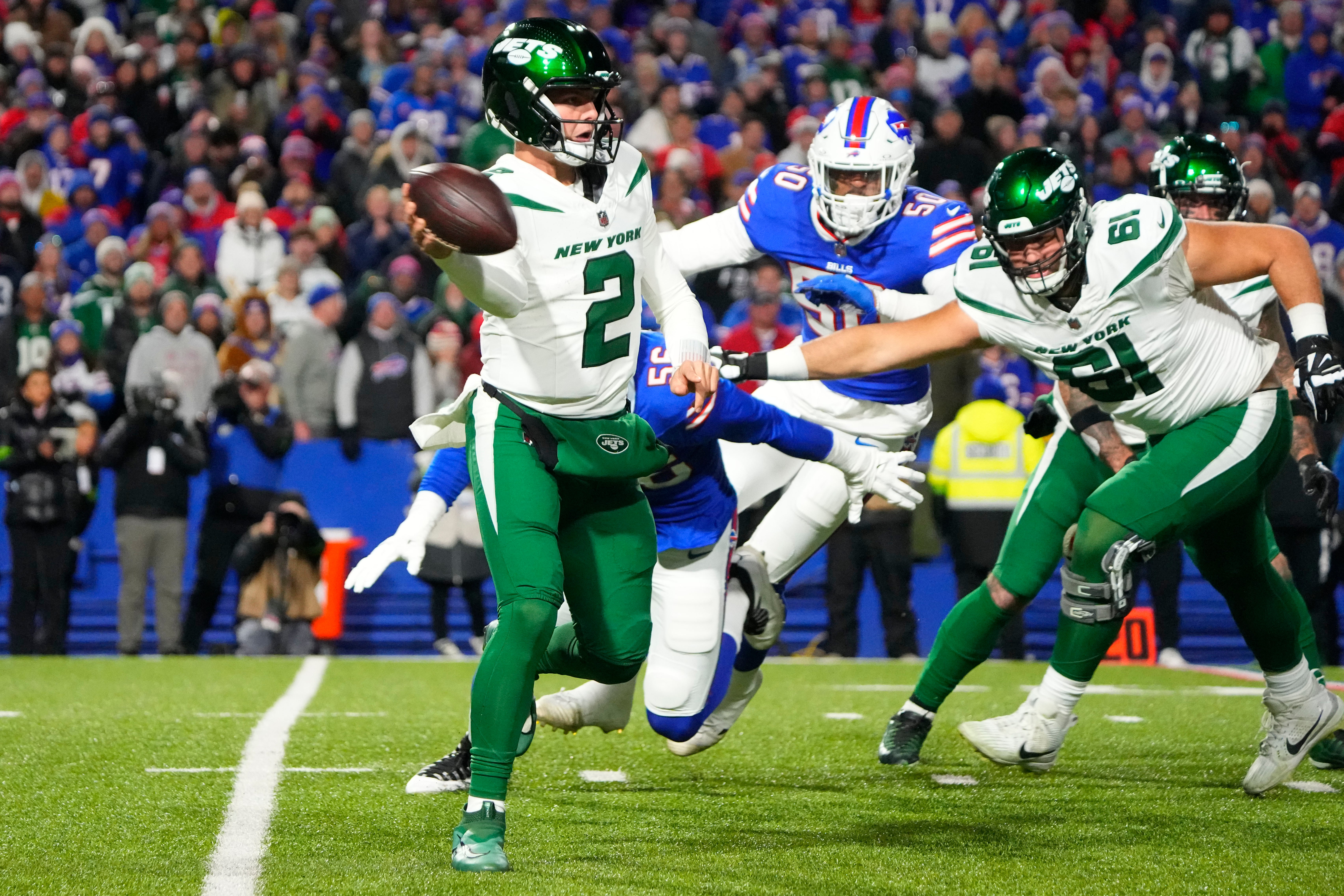 New York Jets quarterback Zach Wilson (2) throws the ball into the ground as he is pressured by Buffalo Bills defensive end Leonard Floyd (56) during the first half at Highmark Stadium.