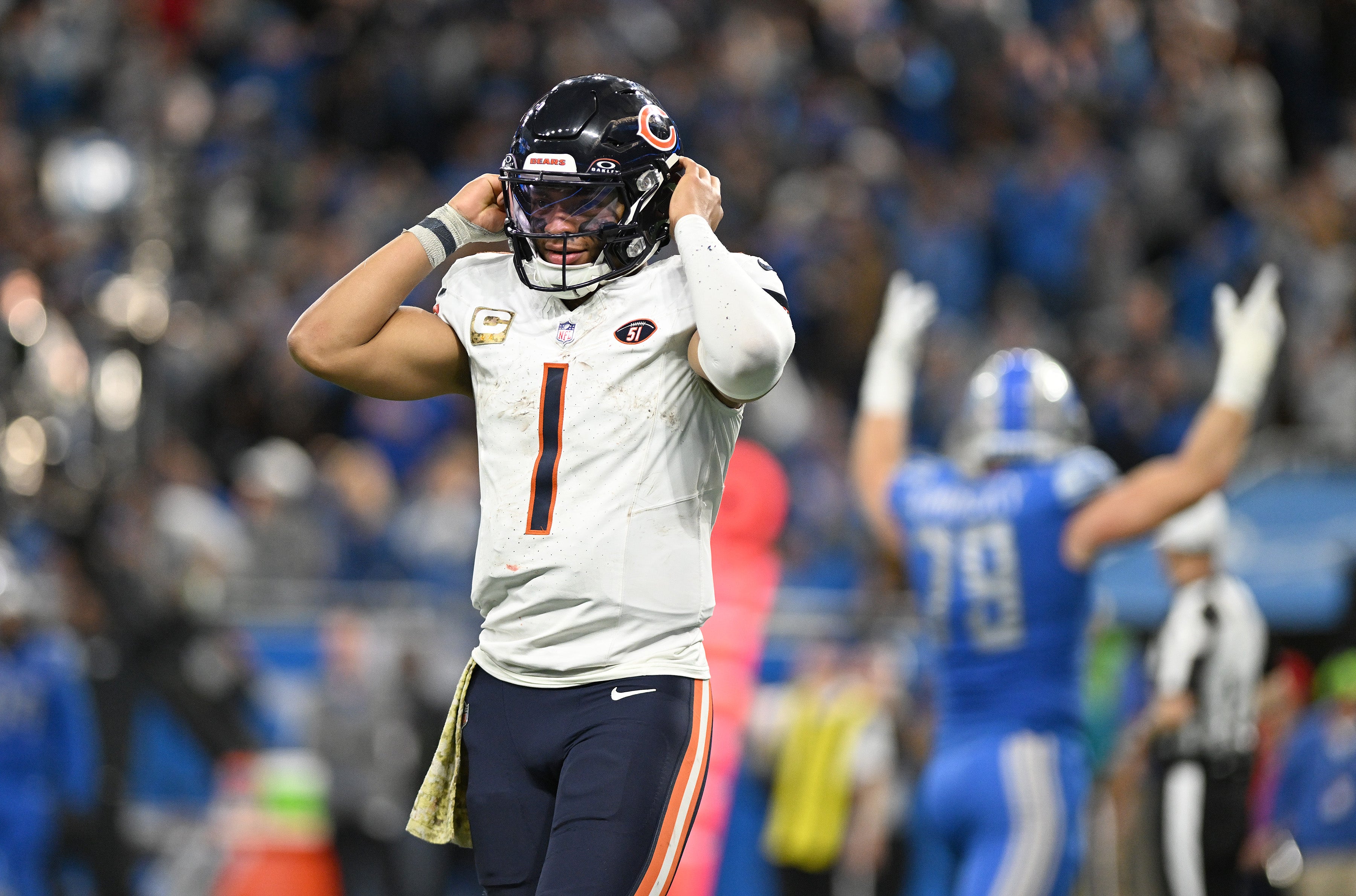 Nov 19, 2023; Detroit, Michigan, USA; Chicago Bears quarterback Justin Fields (1) walks off the field as Detroit Lions defensive end John Cominsky (79) celebrates in the background after stopping the Bears on a third down play in the fourth quarter at Ford Field.