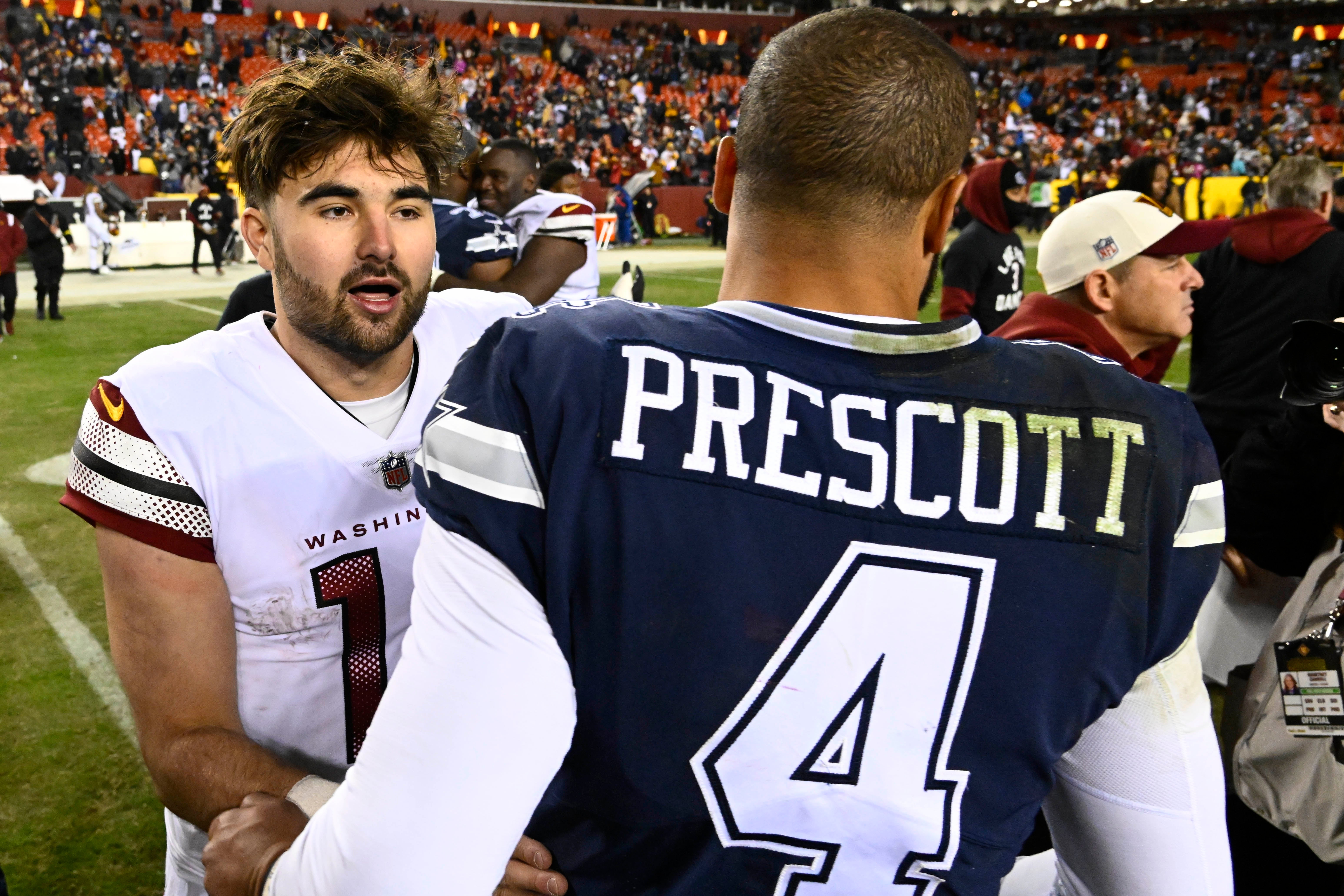 Washington Commanders quarterback Sam Howell (14) talks with Dallas Cowboys quarterback Dak Prescott (4) after the game at FedExField.