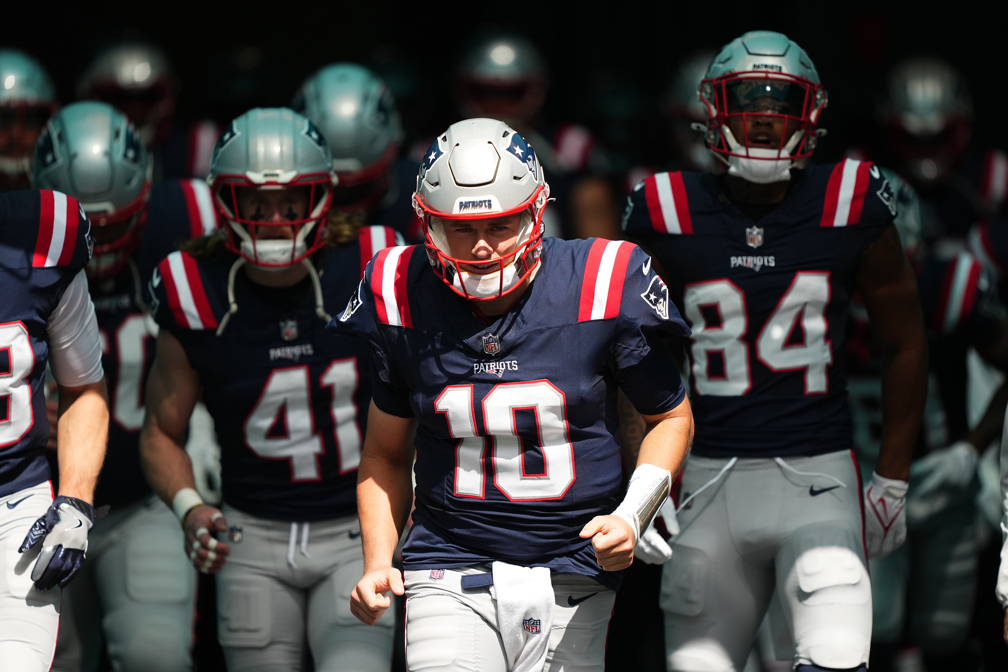 New England Patriots quarterback Mac Jones leads the team to the field prior to the game against the Miami Dolphins at Hard Rock Stadium