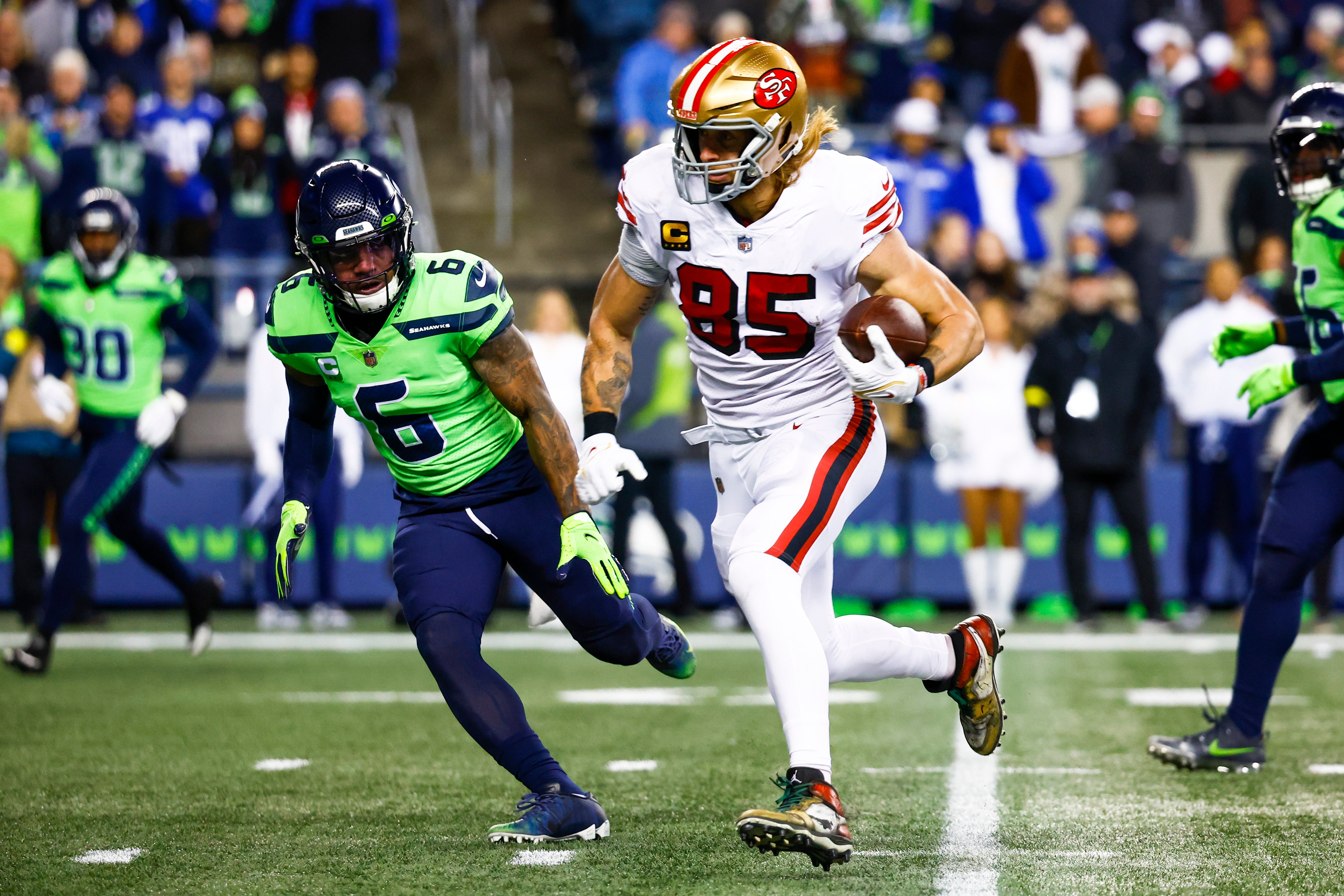 Dec 15, 2022; Seattle, Washington, USA; San Francisco 49ers tight end George Kittle (85) runs for a touchdown against Seattle Seahawks safety Quandre Diggs (6) after making a reception during the first quarter at Lumen Field.