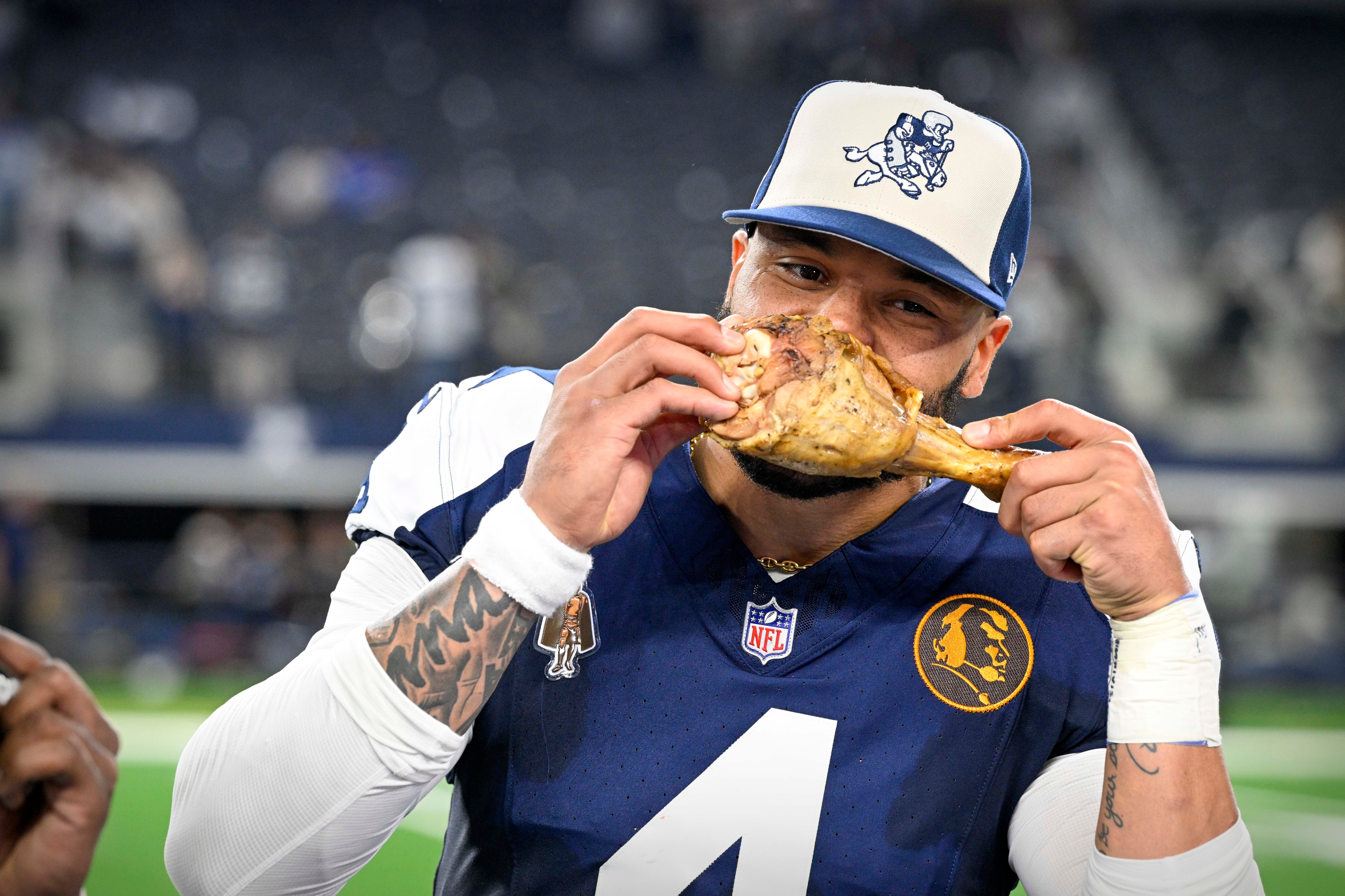 Dak Prescott takes a bite out of a turkey leg after beating the Washington Commanders