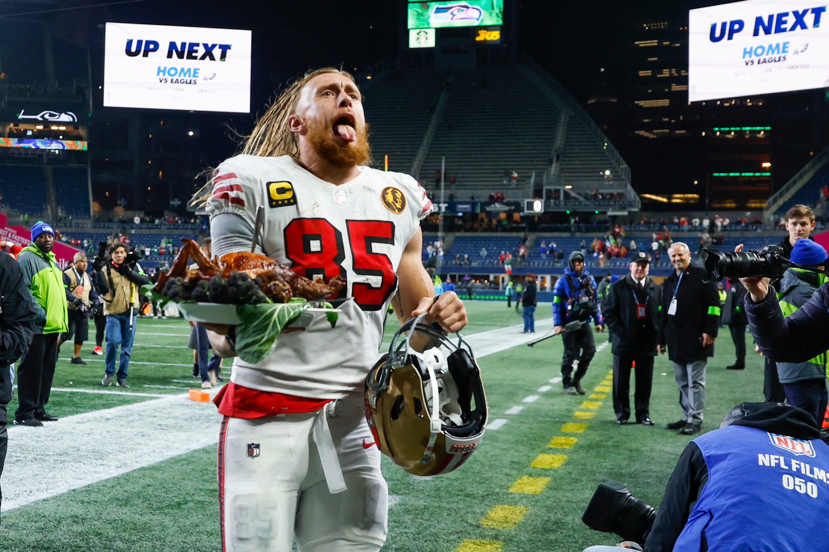 Nov 23, 2023; Seattle, Washington, USA; San Francisco 49ers tight end George Kittle (85) carries a roast turkey as he jogs to the locker room following a 31-13 victory against the Seattle Seahawks at Lumen Field.