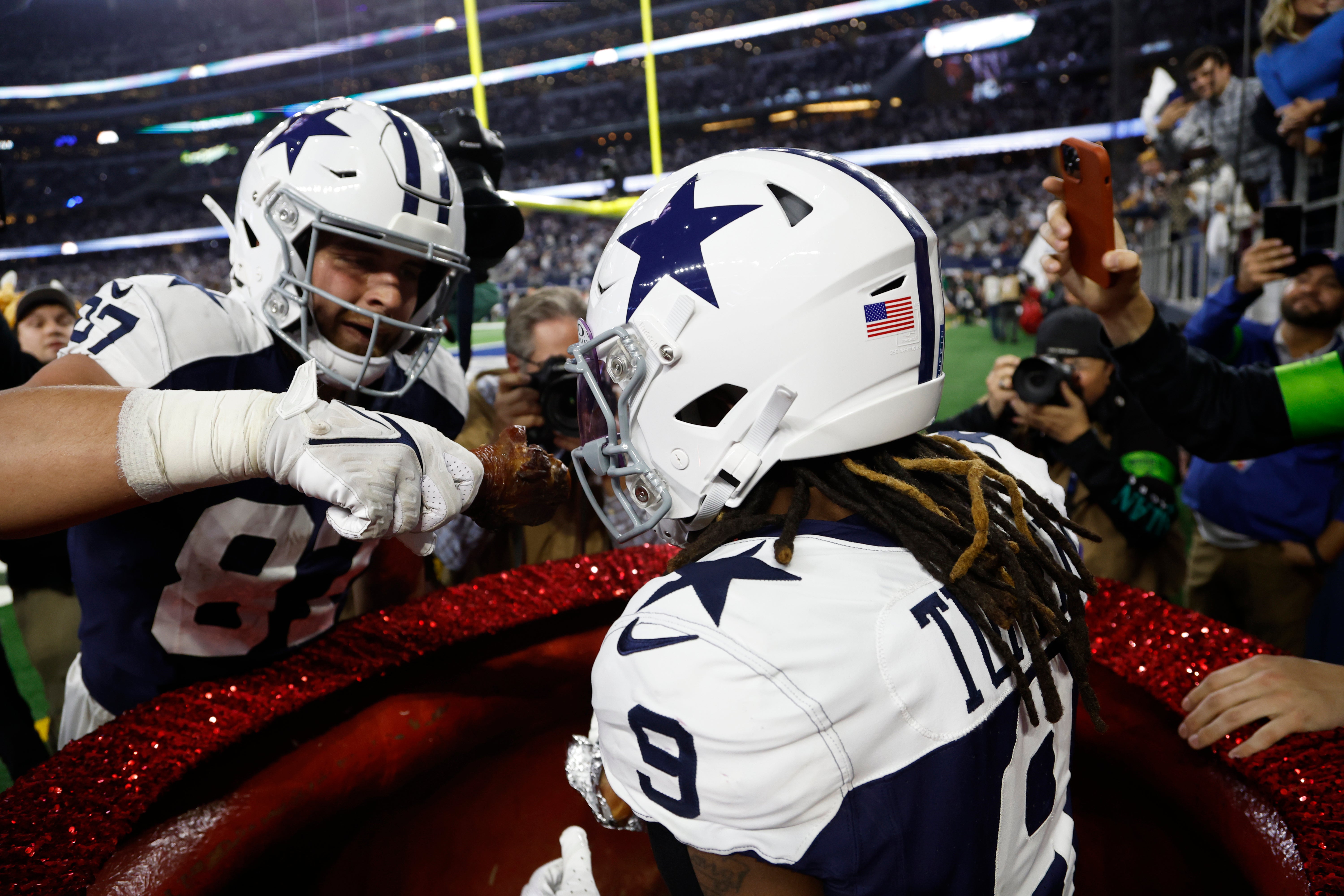 Dallas Cowboys wide receiver KaVontae Turpin (9) eats a turkey leg as tight end Jake Ferguson (87) feeds him in the fourth quarter against the Washington Commanders at AT&T Stadium.