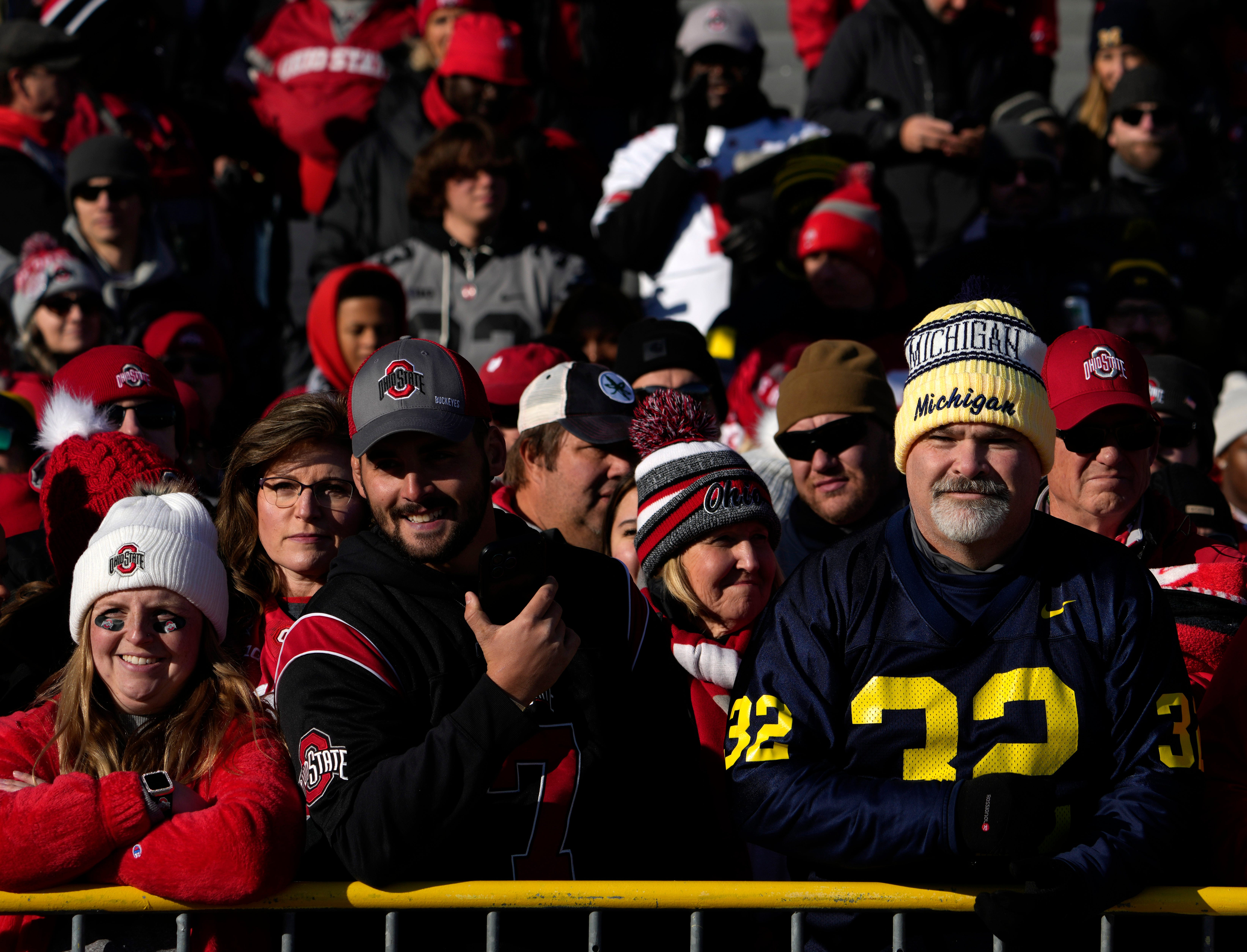 Michigan fan stands among a scarlet sea of Ohio State fans waiting for the team to arrive outside of Michigan Stadium before Saturday s NCAA Division I football game against the Ohio State Buckeyes and the Michigan Wolverines at Michigan Stadium.
