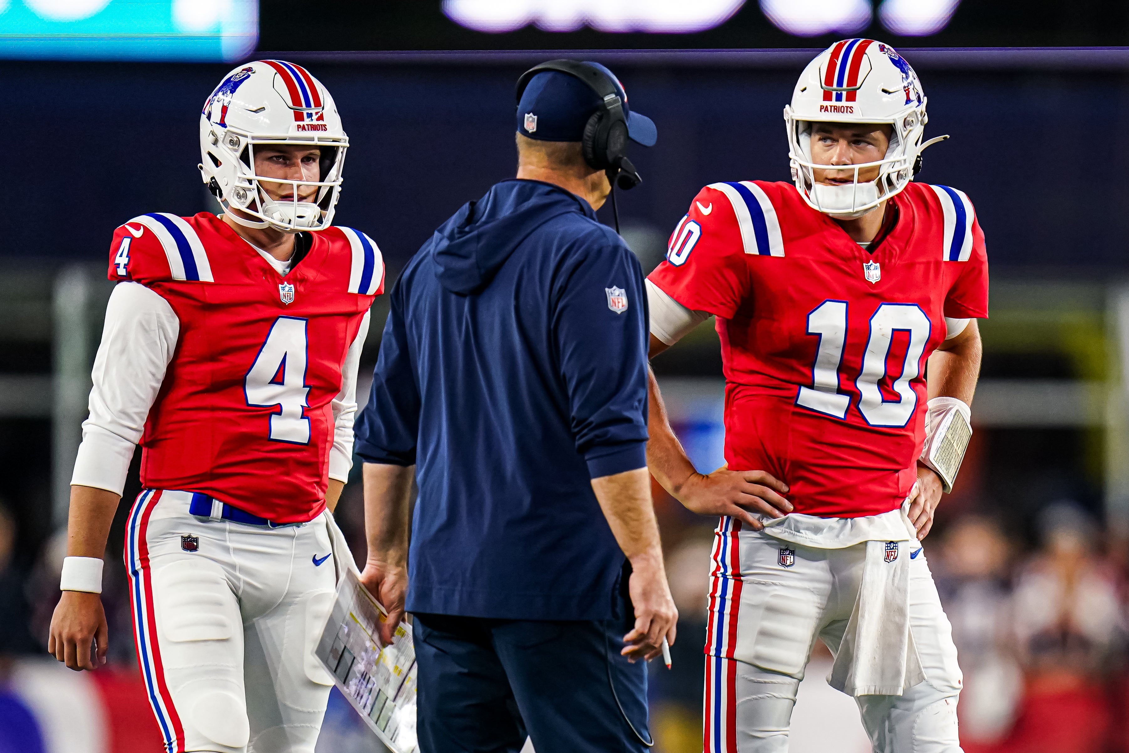 New England Patriots quarterback Mac Jones (10) and quarterback Bailey Zappe talk with offensive coordinator/quarterbacks coach Bill O'Brien in the second quarter at Gillette Stadium.