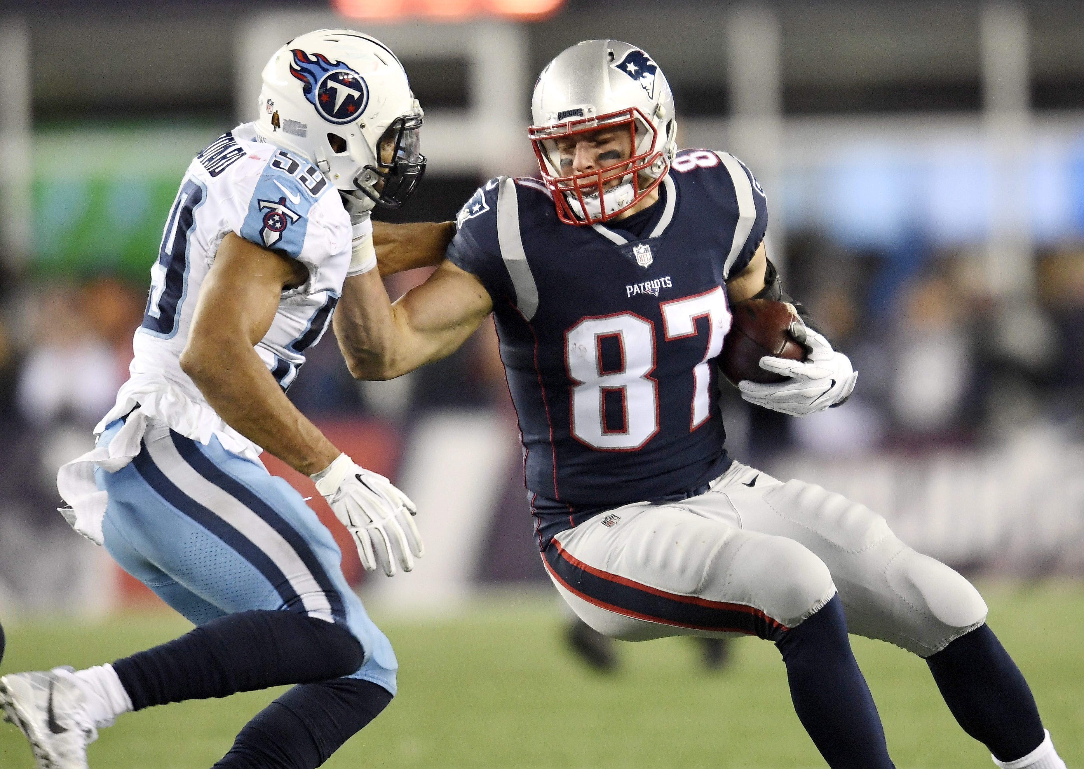 New England Patriots tight end Rob Gronkowski (87) attempts to push off Tennessee Titans linebacker Wesley Woodyard (59) after a big gain during the AFC Divisional Round playoff game at Gillette Stadium in Foxborough, Mass., Jan. 13, 2018.