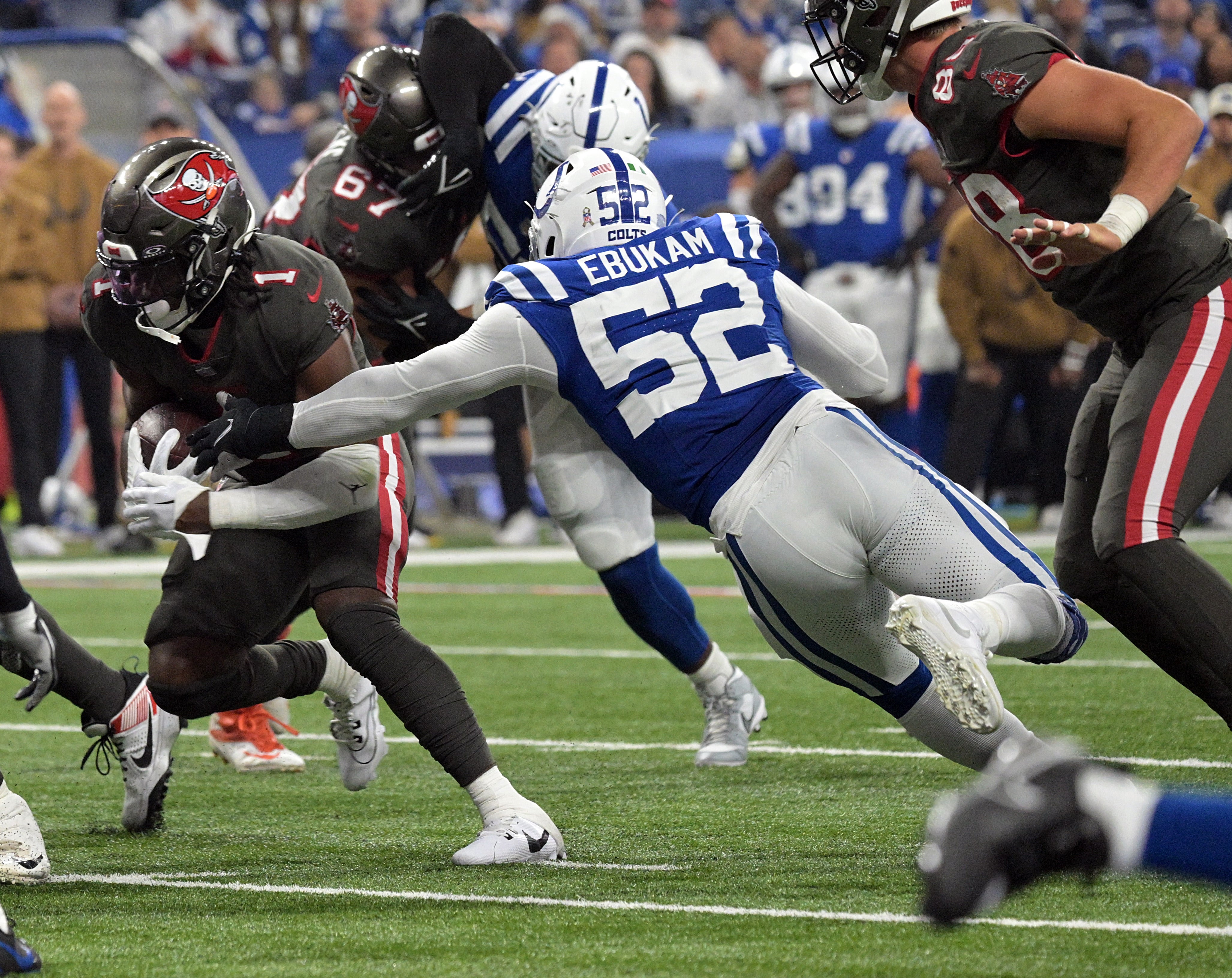 Nov 26, 2023; Indianapolis, Indiana, USA; Indianapolis Colts defensive end Samson Ebukam (52) reaches to tackle Tampa Bay Buccaneers running back Rachaad White (1) during the first quarter at Lucas Oil Stadium.