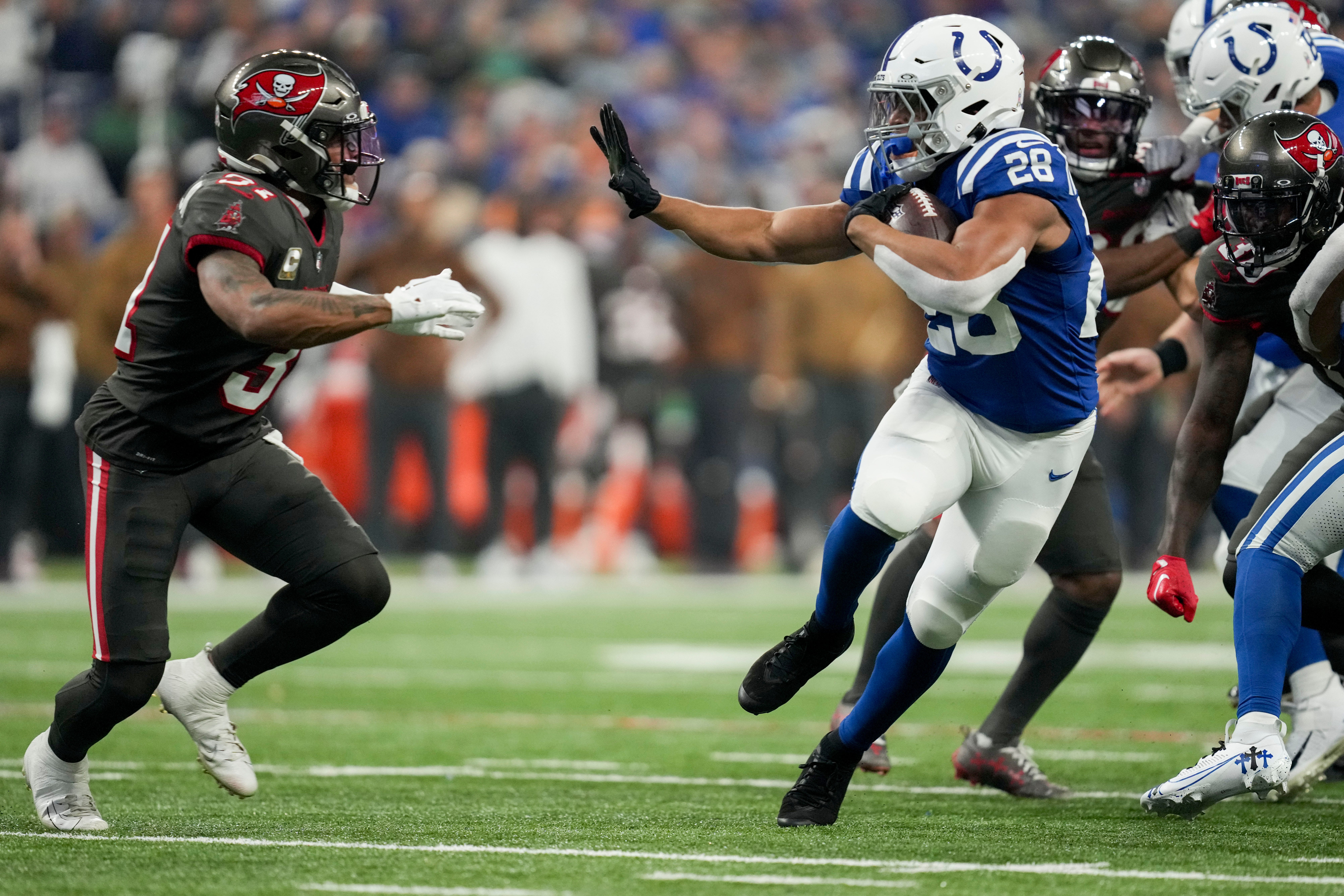 Indianapolis Colts running back Jonathan Taylor (28) looks to stiff arm Tampa Bay Buccaneers safety Antoine Winfield Jr. (31) Sunday, Nov. 26, 2023, during a game against the Tampa Bay Buccaneers at Lucas Oil Stadium in Indianapolis.