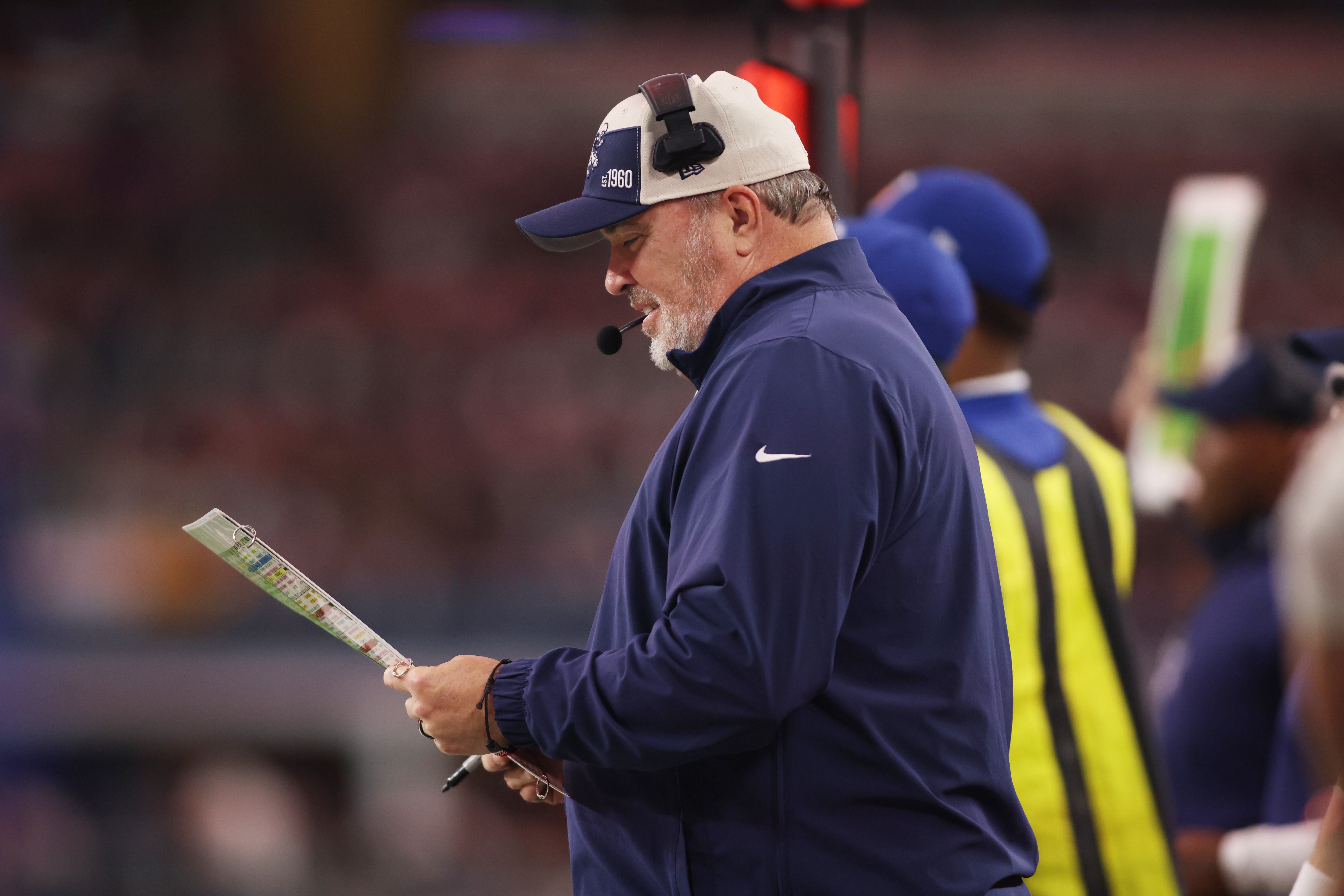 Nov 23, 2023; Arlington, Texas, USA; Dallas Cowboys Mike McCarthy looks at the play sheet in then first quarter against the Washington Commanders at AT&T Stadium.