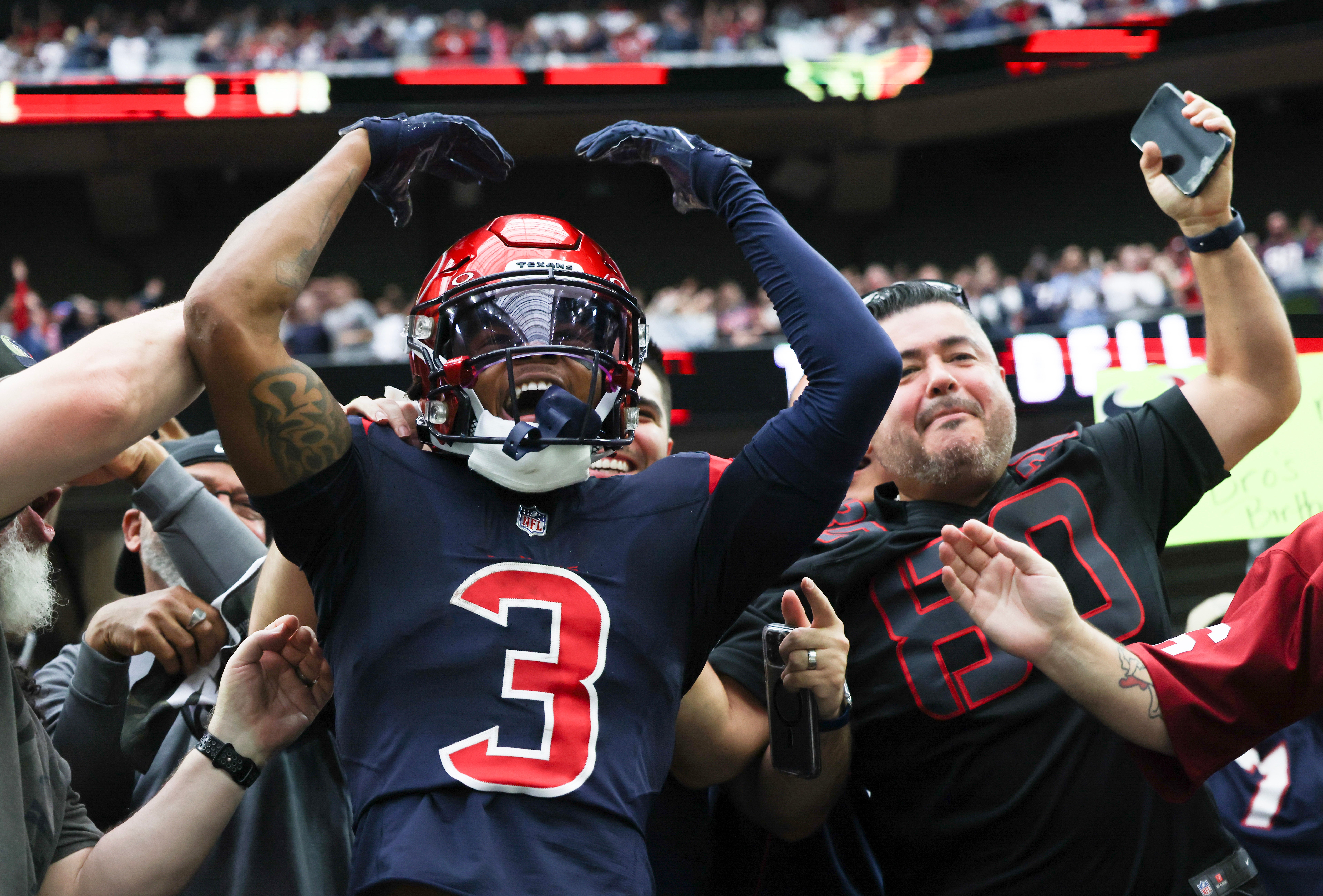 Nov 19, 2023; Houston, Texas, USA; Houston Texans wide receiver Tank Dell (3) jumps in the stands and celebrates his touchdown against the Arizona Cardinals in the second quarter at NRG Stadium.