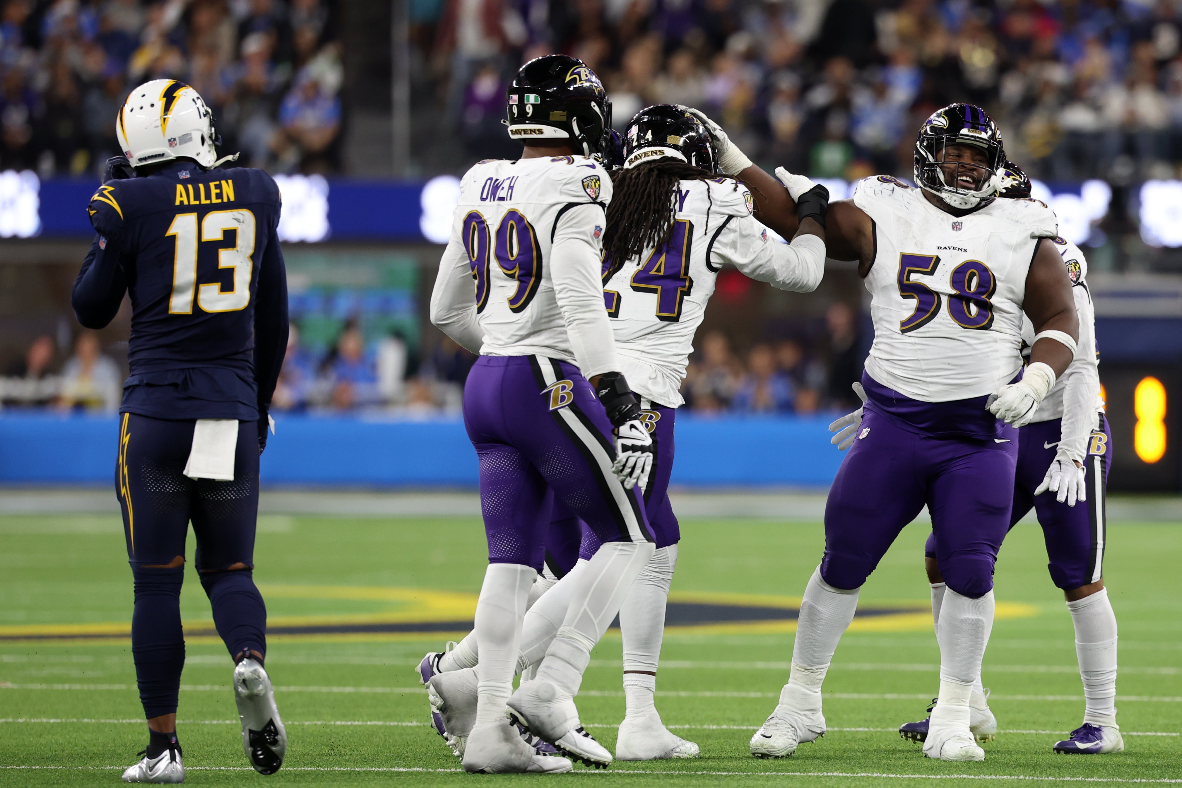 Baltimore Ravens linebacker Jadeveon Clowney (24) is greeted by defensive tackle Michael Pierce (58) after he recovered a fumble during the fourth quarter against the Los Angeles Chargers at SoFi Stadium. 