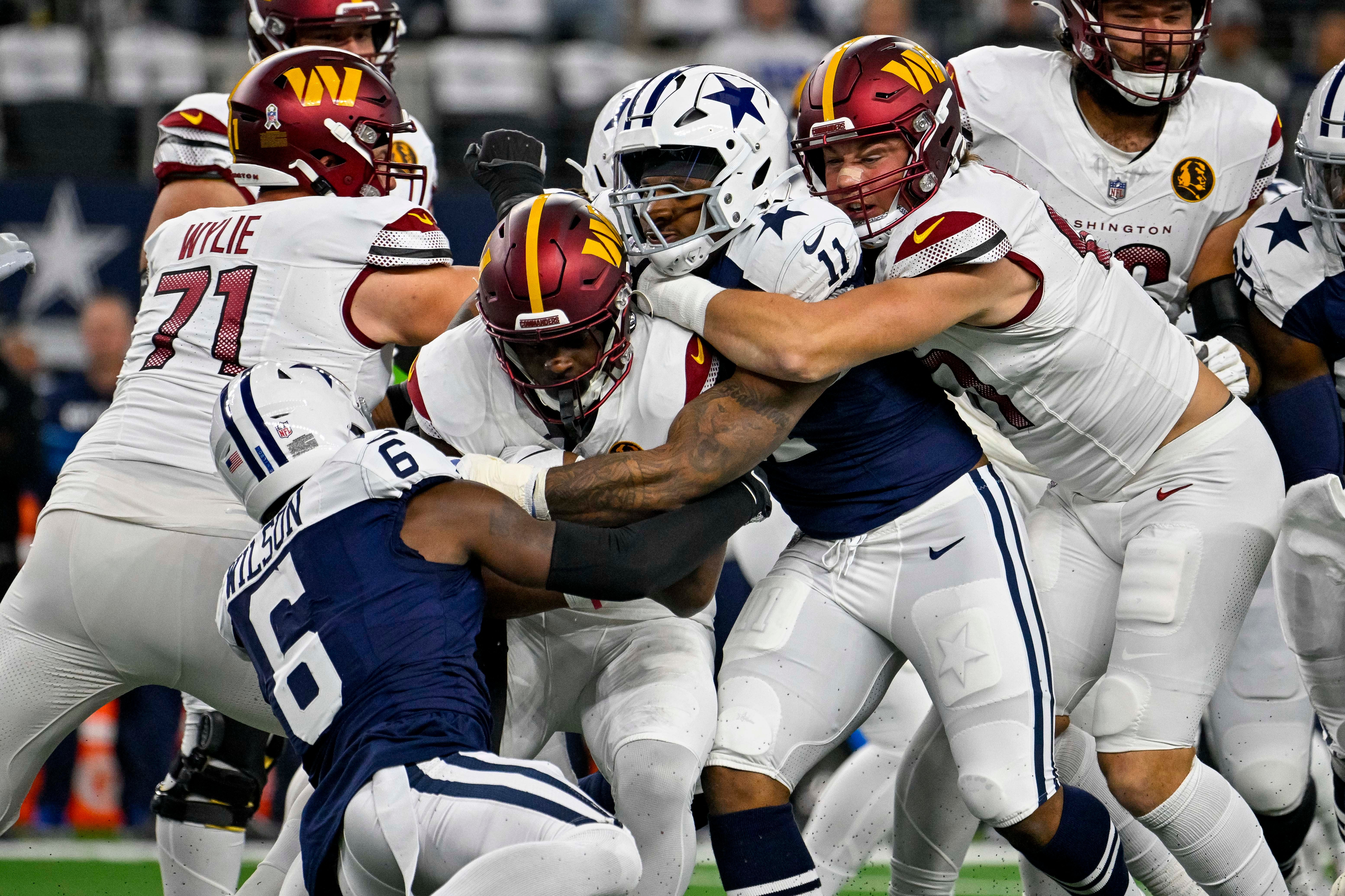 Dallas Cowboys safety Donovan Wilson (6) and linebacker Micah Parsons (11) and Washington Commanders running back Brian Robinson Jr. (8) in action during the game between the Dallas Cowboys and the Washington Commanders at AT&T Stadium.