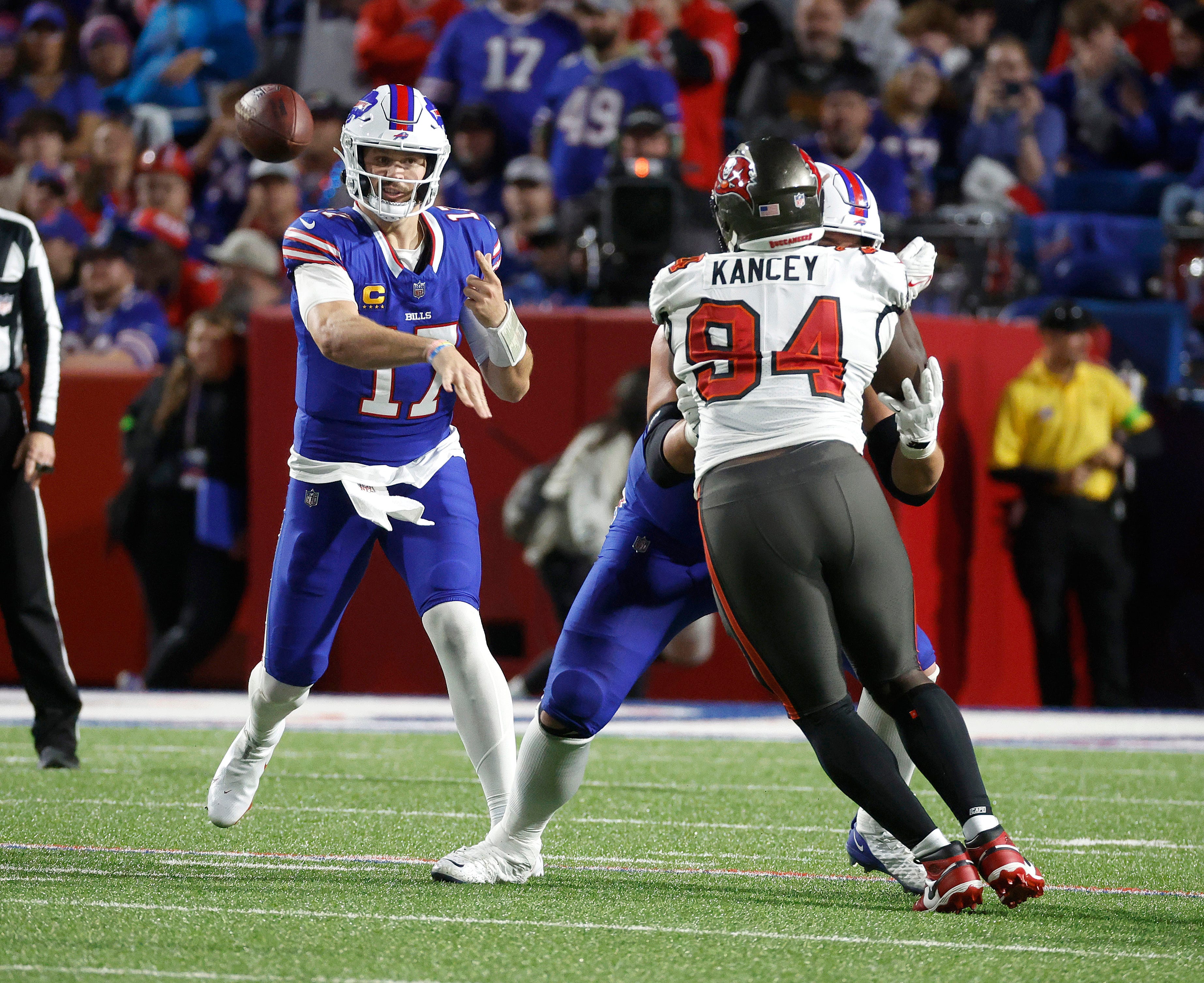 Buffalo Bills quarterback Josh Allen (17) throws around Tampa Bay Buccaneers defensive tackle Calijah Kancey (94).